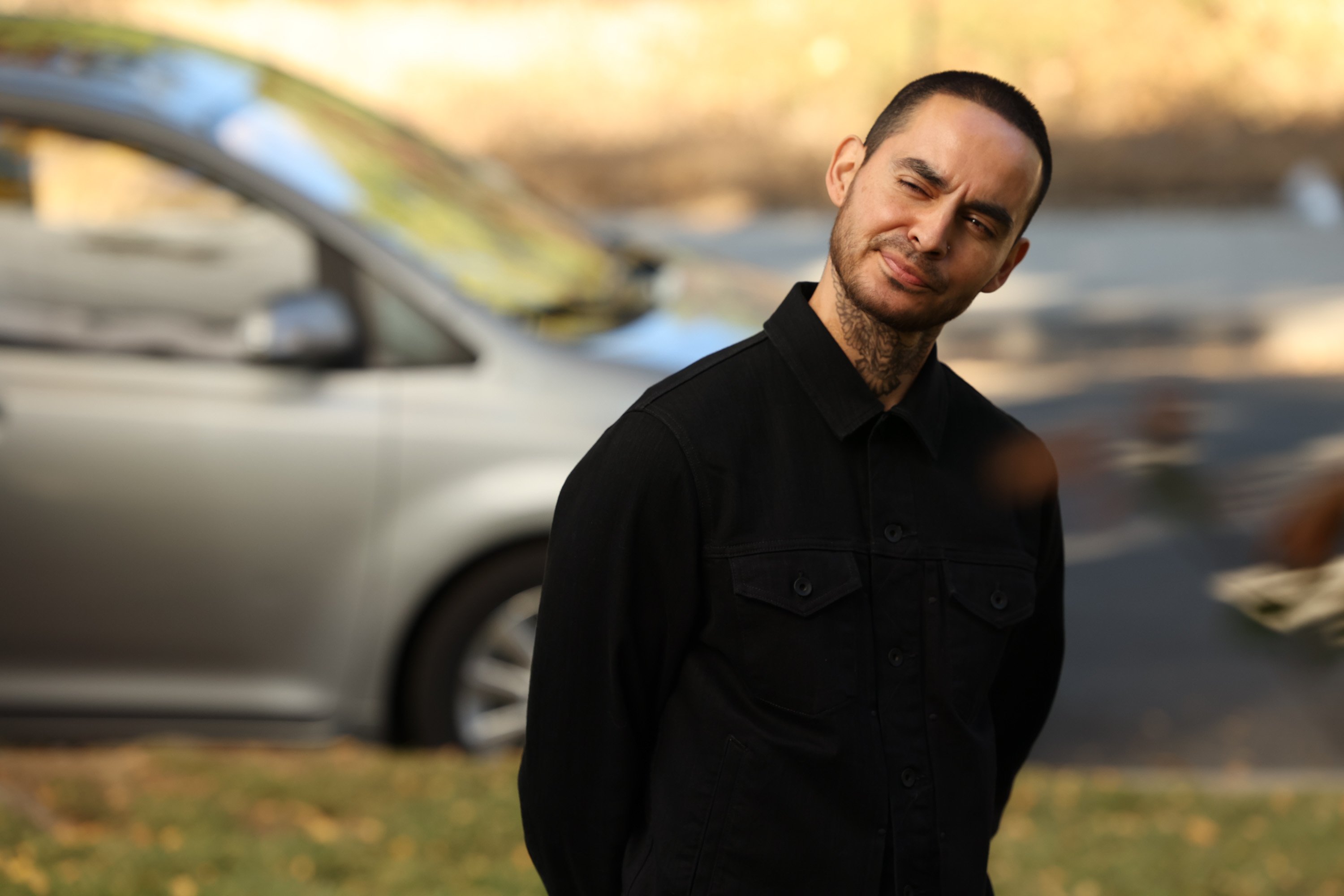 'Good Girls' star Manny Montana as Rio tilting his head and smirking while standing outside.
