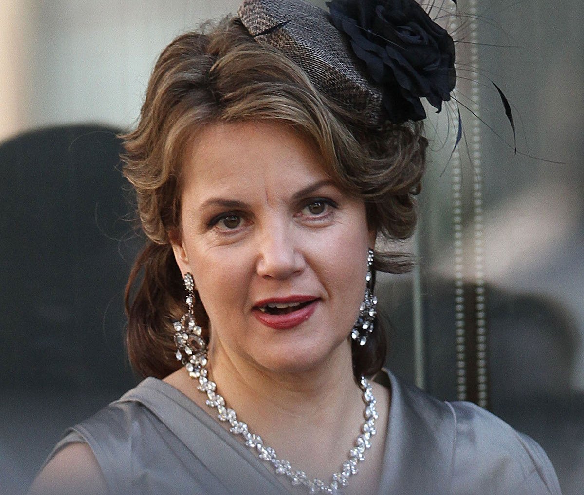 Margaret Colin has her hair up and makeup done to film 'Gossip Girl'. She wears pearls and dangling earrings. 