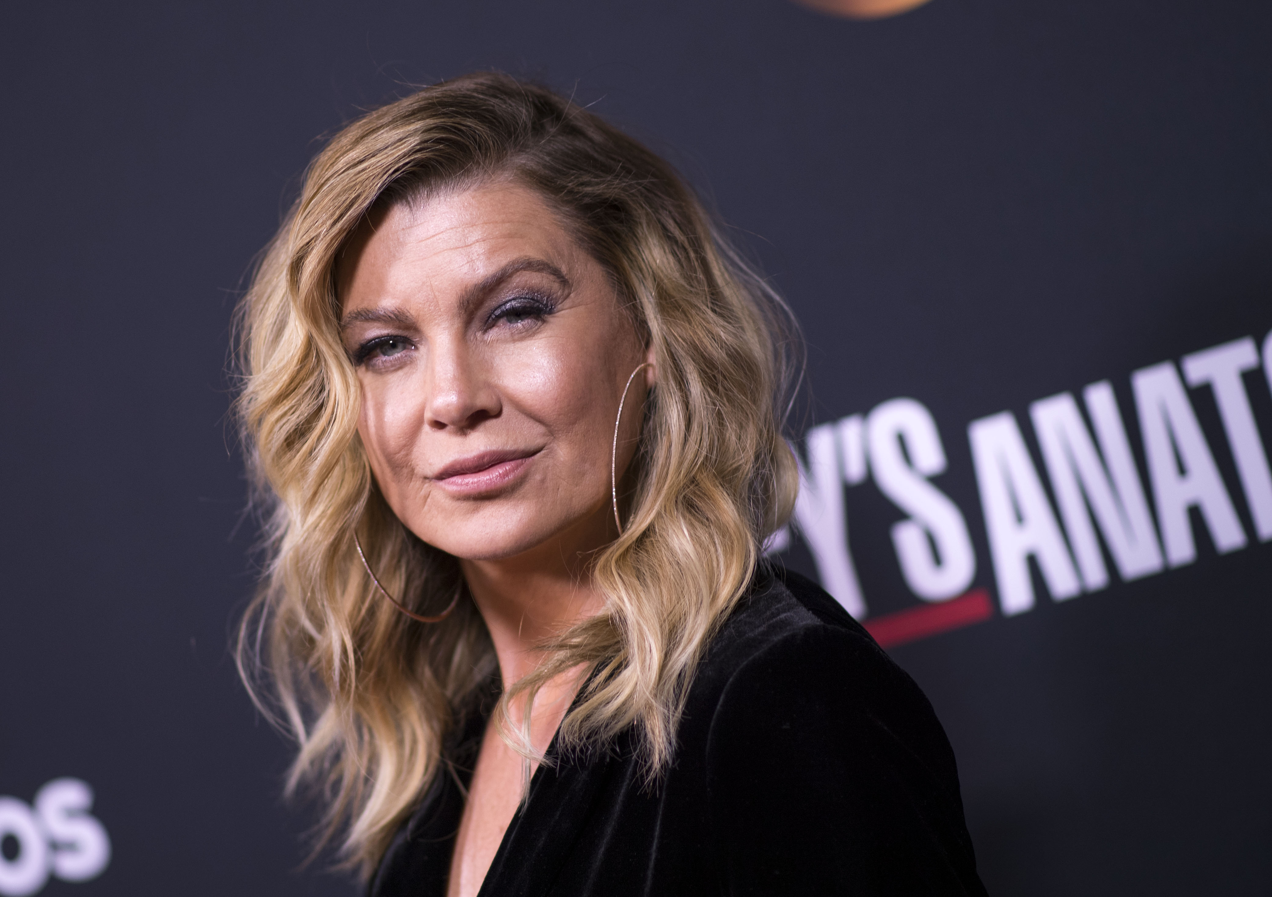 'Grey's Anatomy' star Ellen Pompeo smirking as she looks at the camera while attending an event.