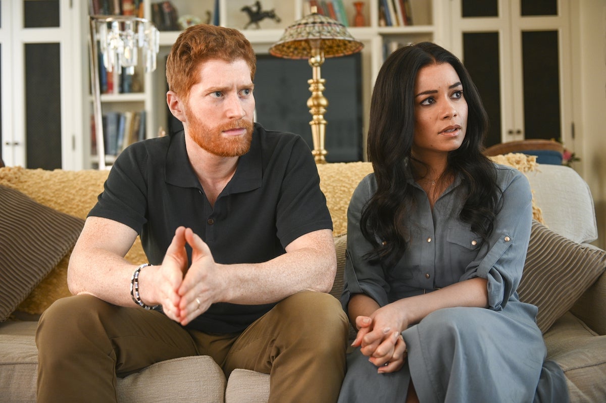 Harry and Meghan sitting on a couch in 'Harry & Meghan: Escaping the Palace'