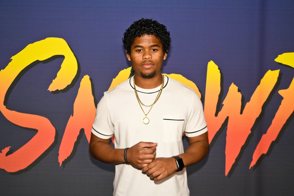 Isaiah John poses for a photo at an event for the FX series 'Snowfall' wearing a white shirt