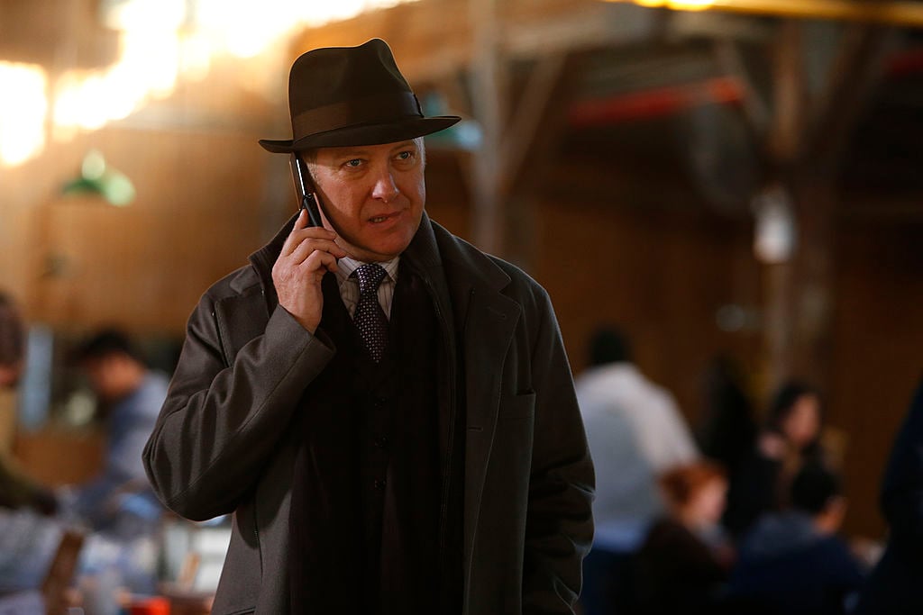 James Spader as Raymond 'Red' Reddington stands outside on his cellphone with a concerned look on his face.