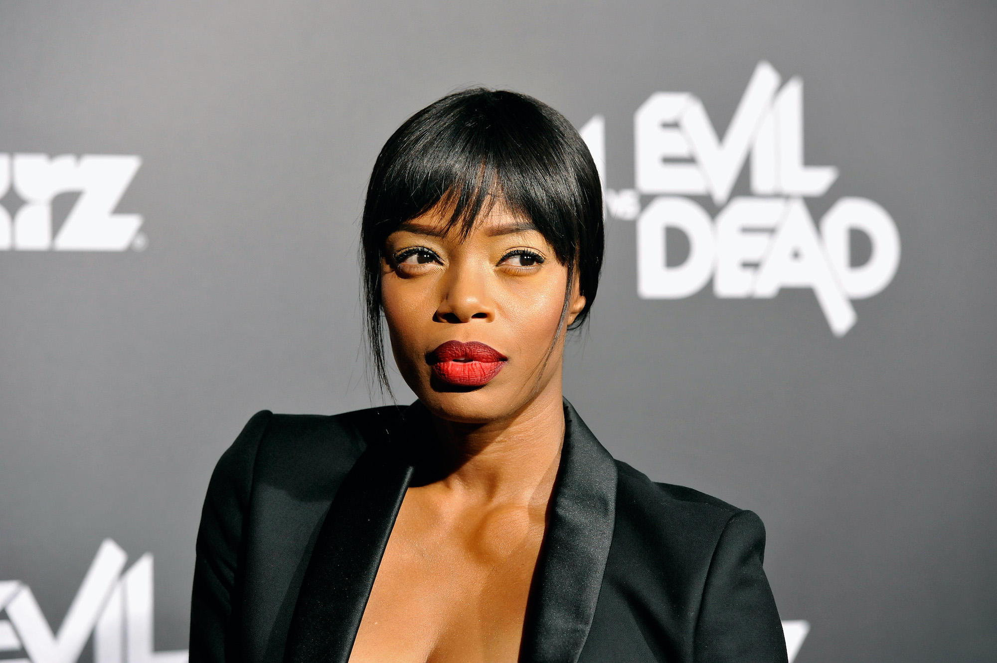 Jill Marie Jones smiling in front of a gray background