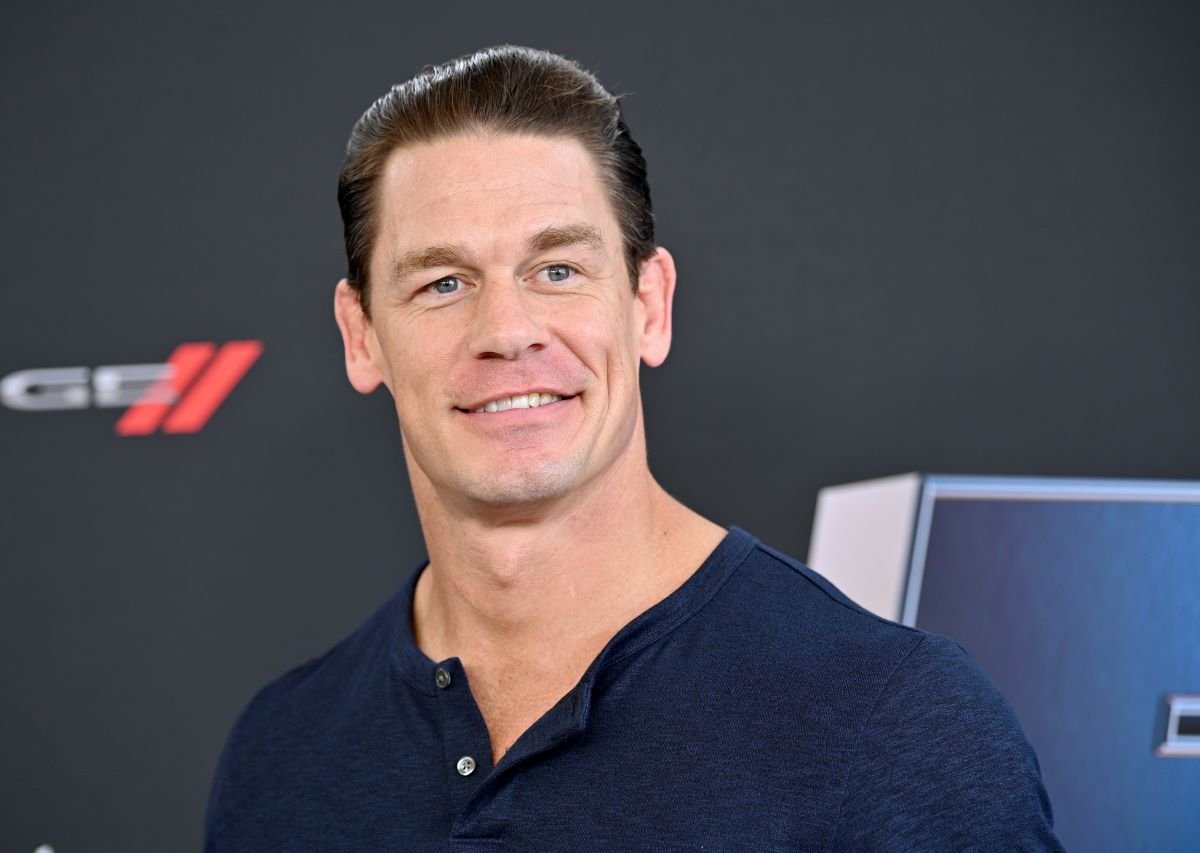 WWE star John Cena smiling in a navy blue shirt