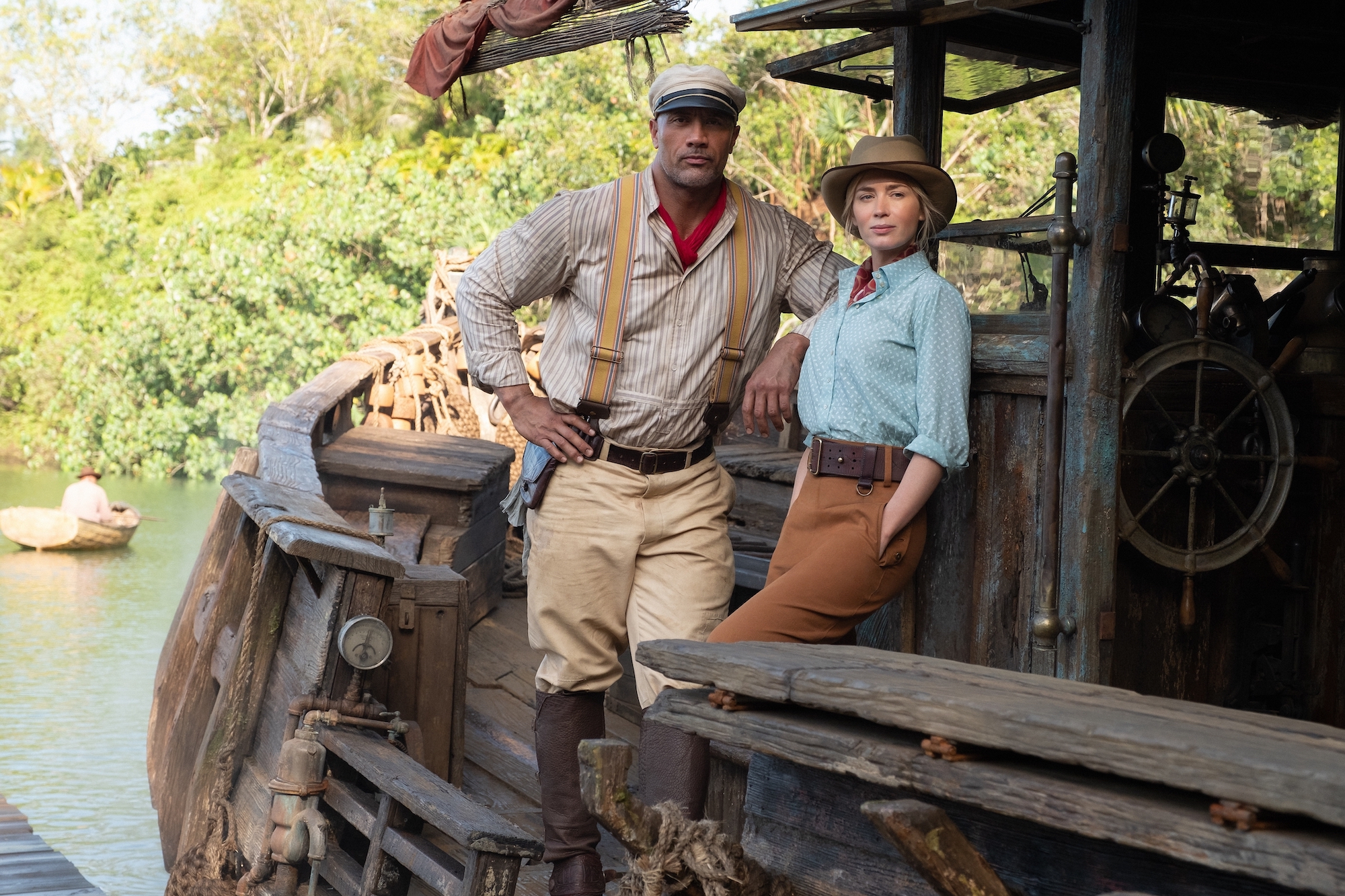 Jungle cruise captain Dwayne Johnson and passenger Emily Blunt lean on the boat