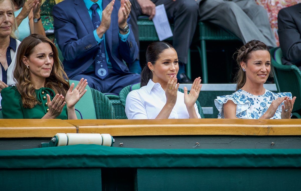Kate Middleton, Meghan Markle, and Pippa Middleton sitting and clapping in the Royal Box for the Ladies Singles Final at Wimbledon in 2019