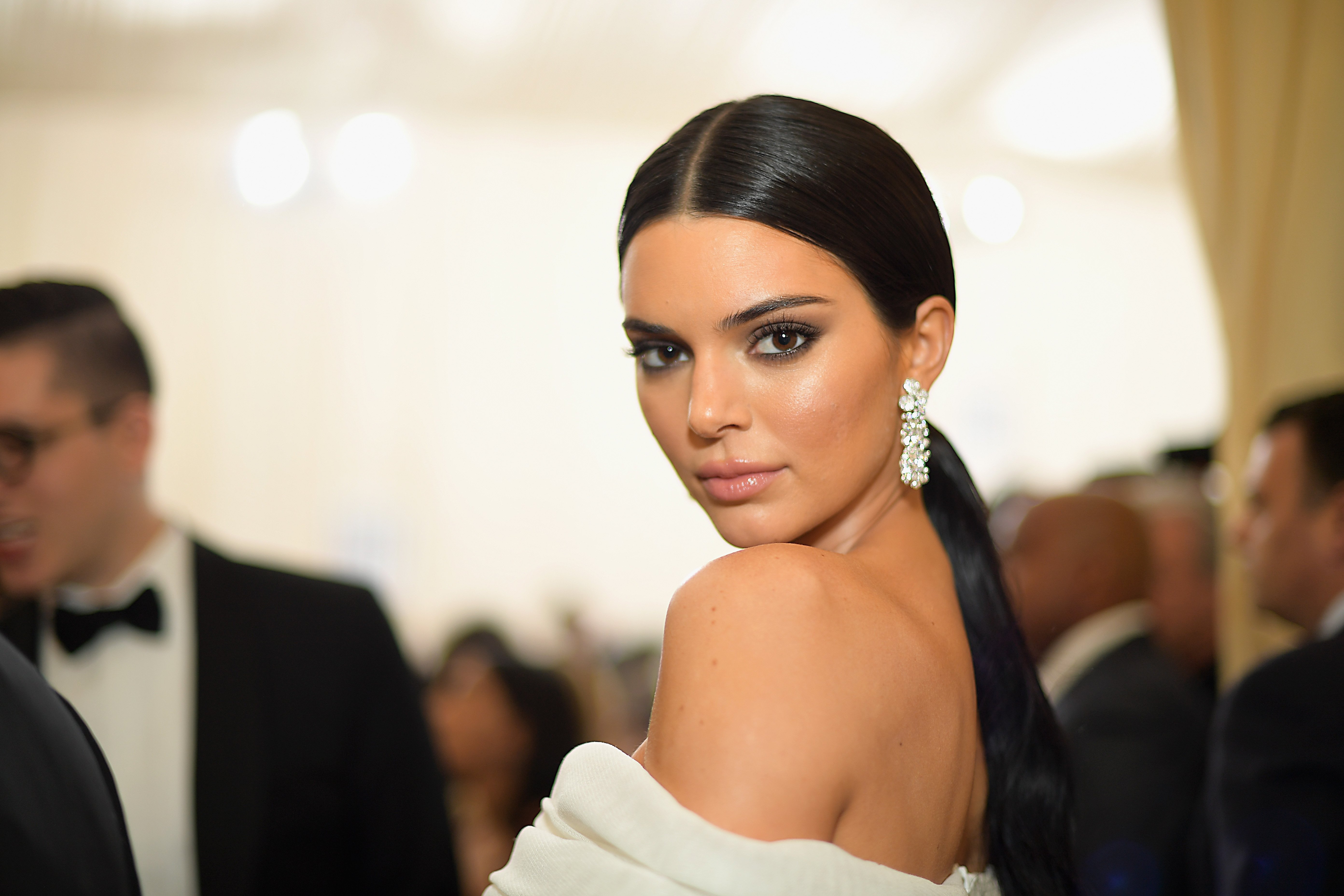 Kendall Jenner glaring at the camera while wearing a white gown.