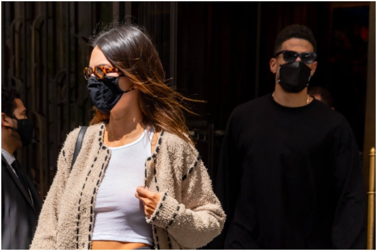 Kendall Jenner and Devin Booker standing outside while wearing masks.