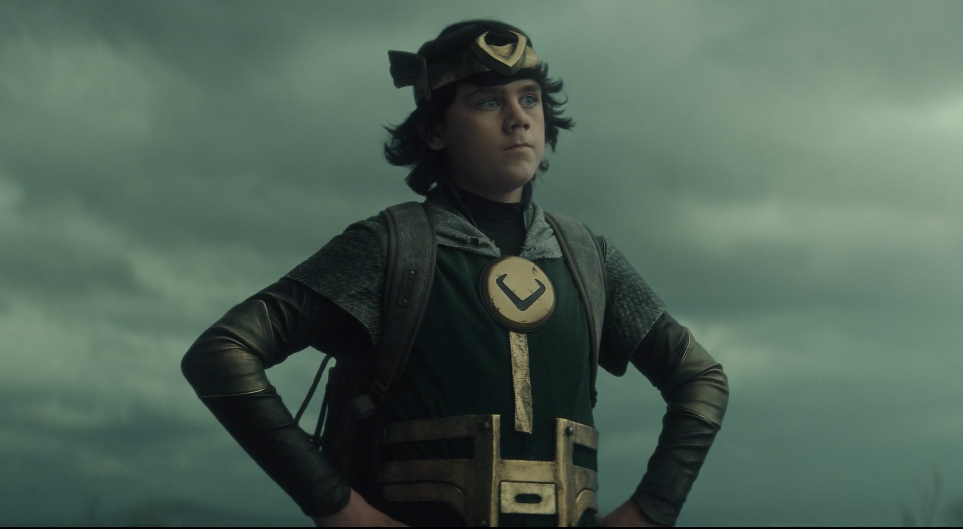 Kid Loki (Jack Veal) standing with his hands on his hips