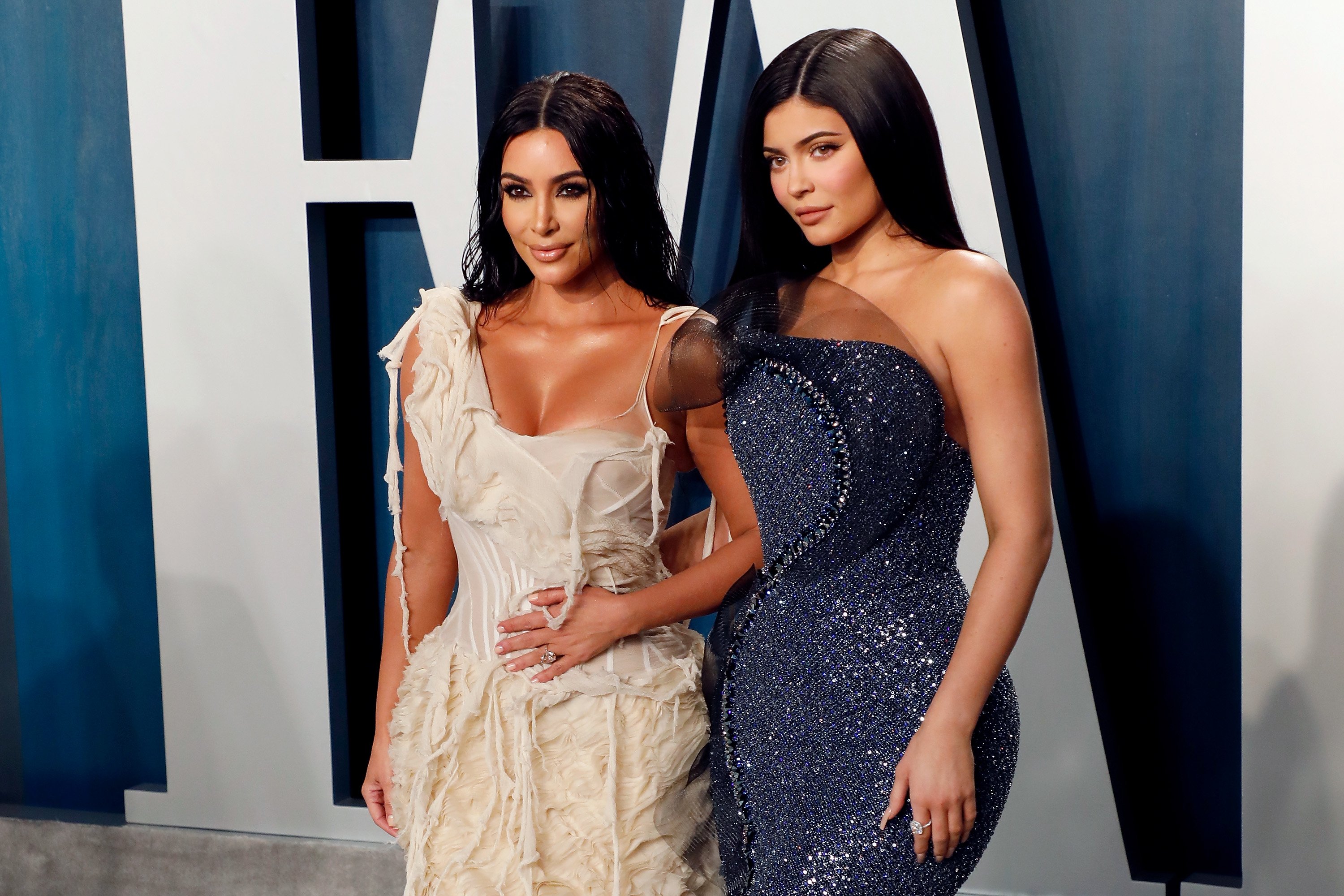 Kim Kardashian West and Kylie Jenner pose together in evening gowns at the 2020 Vanity Fair Oscar Party