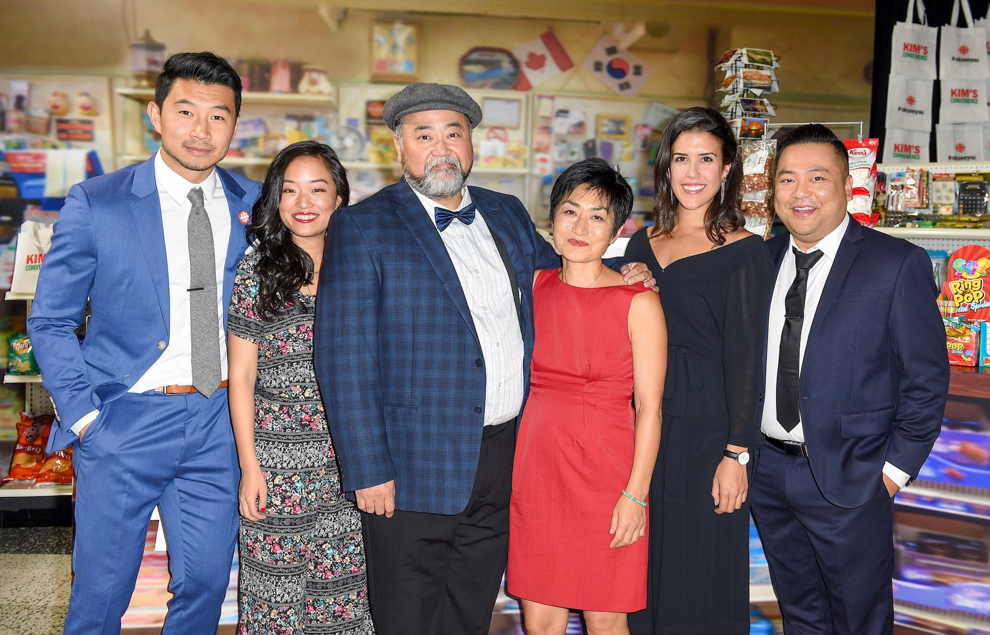 Cast of 'Kim's Convenience' smiling in front of a convenience store backdrop