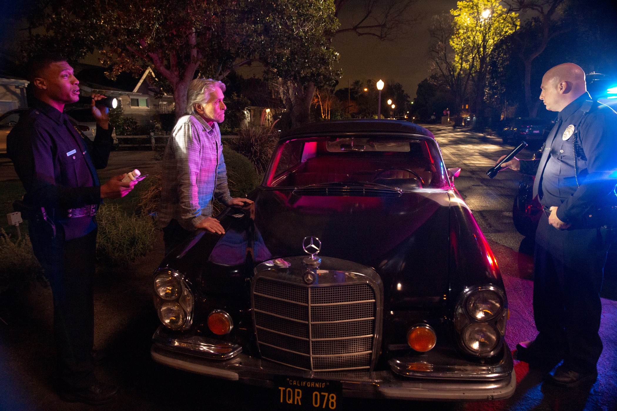 Michael Douglas as Sandy Kominsky speaks to police next to his classic car in season 2 of 'The Kominsky Method' 