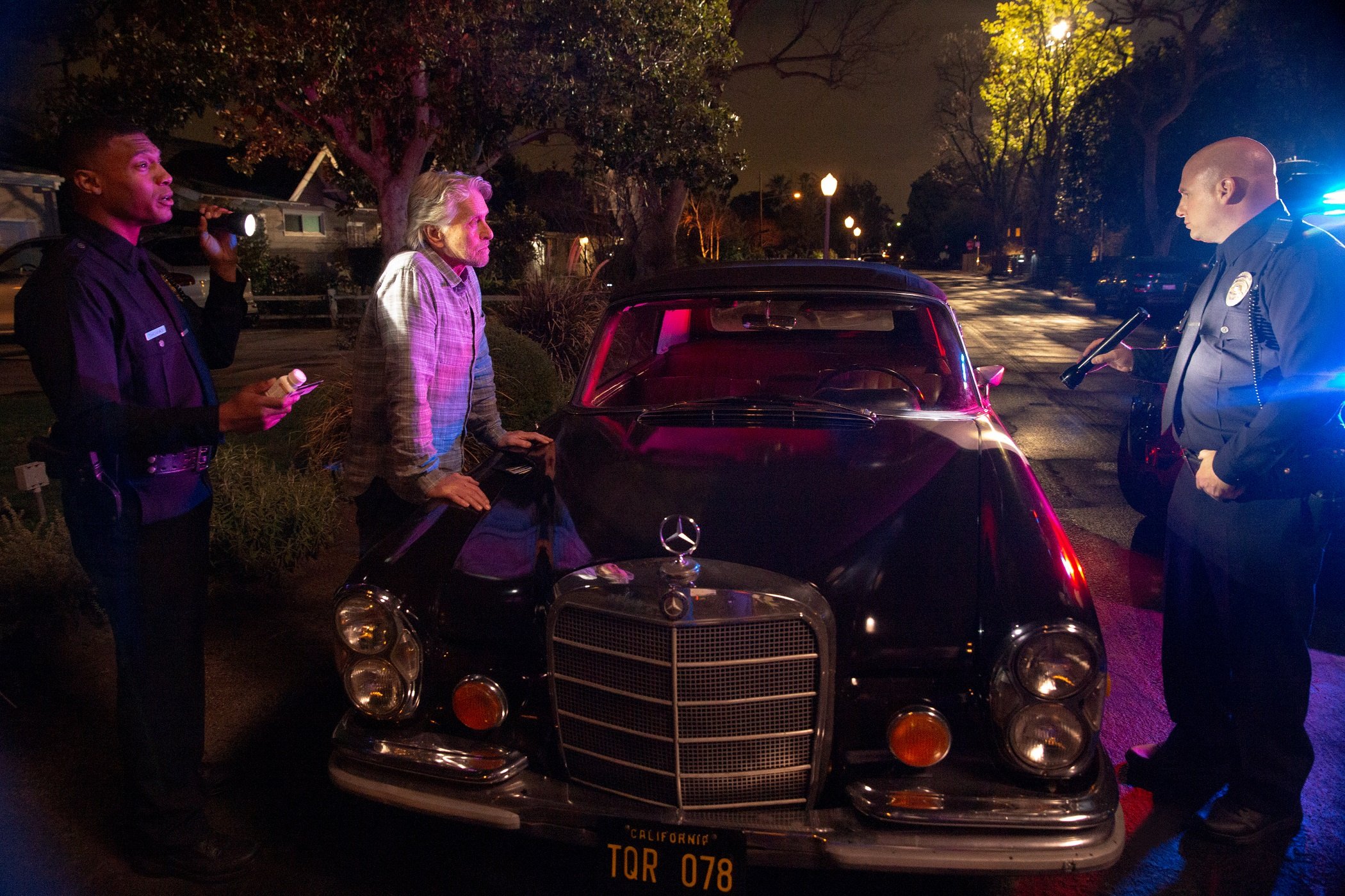 Michael Douglas as Sandy Kominsky speaks to police next to his classic car in season 2 of 'The Kominsky Method'