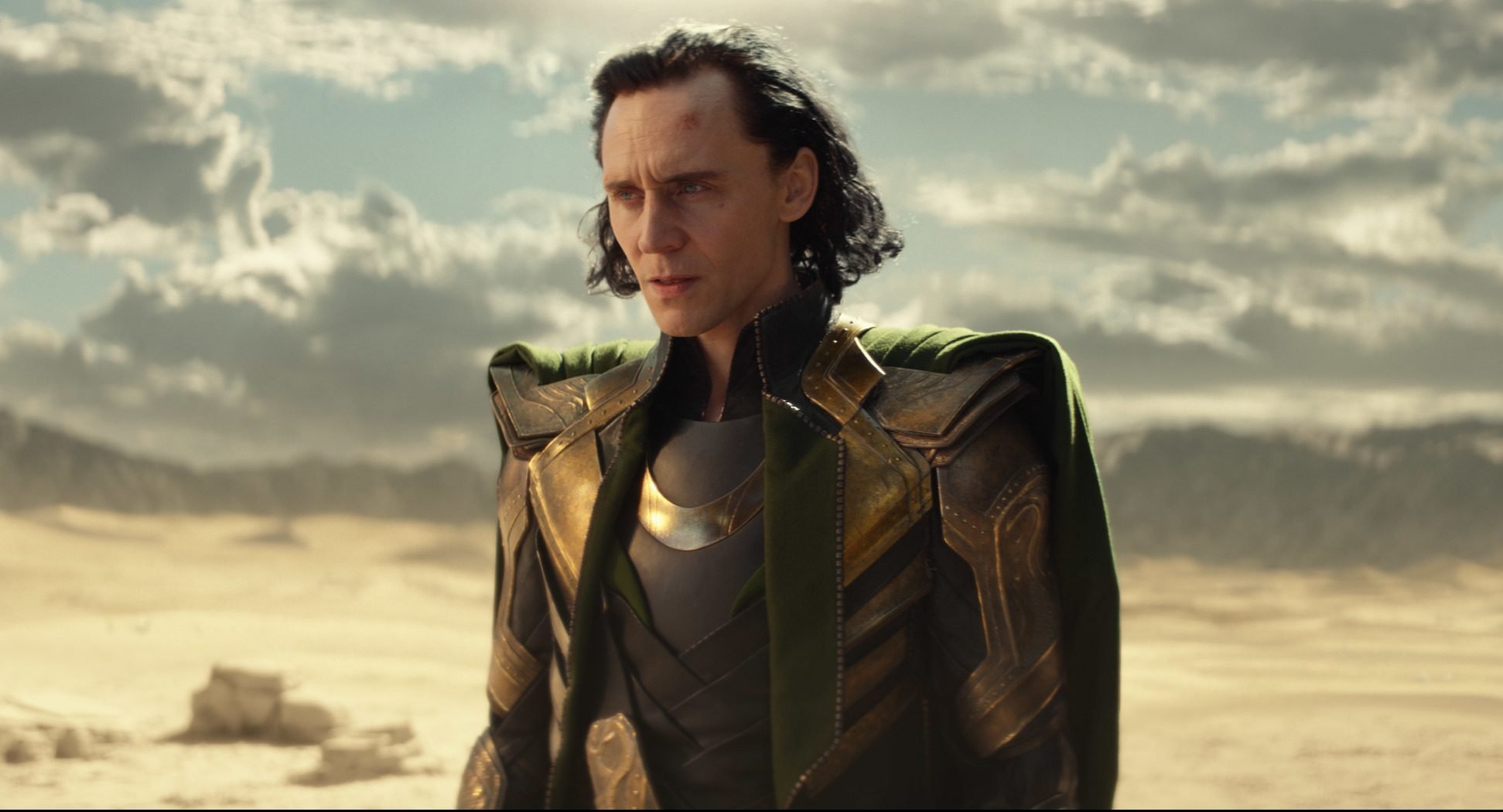 'Loki' star Tom Hiddleston standing in a desert landscape during the show's first episode