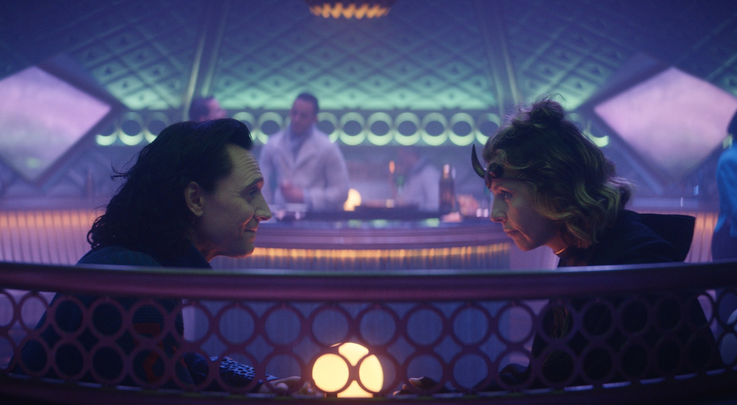 Loki and Sylvie sit across from one another at a table in 'Loki' Episode 3