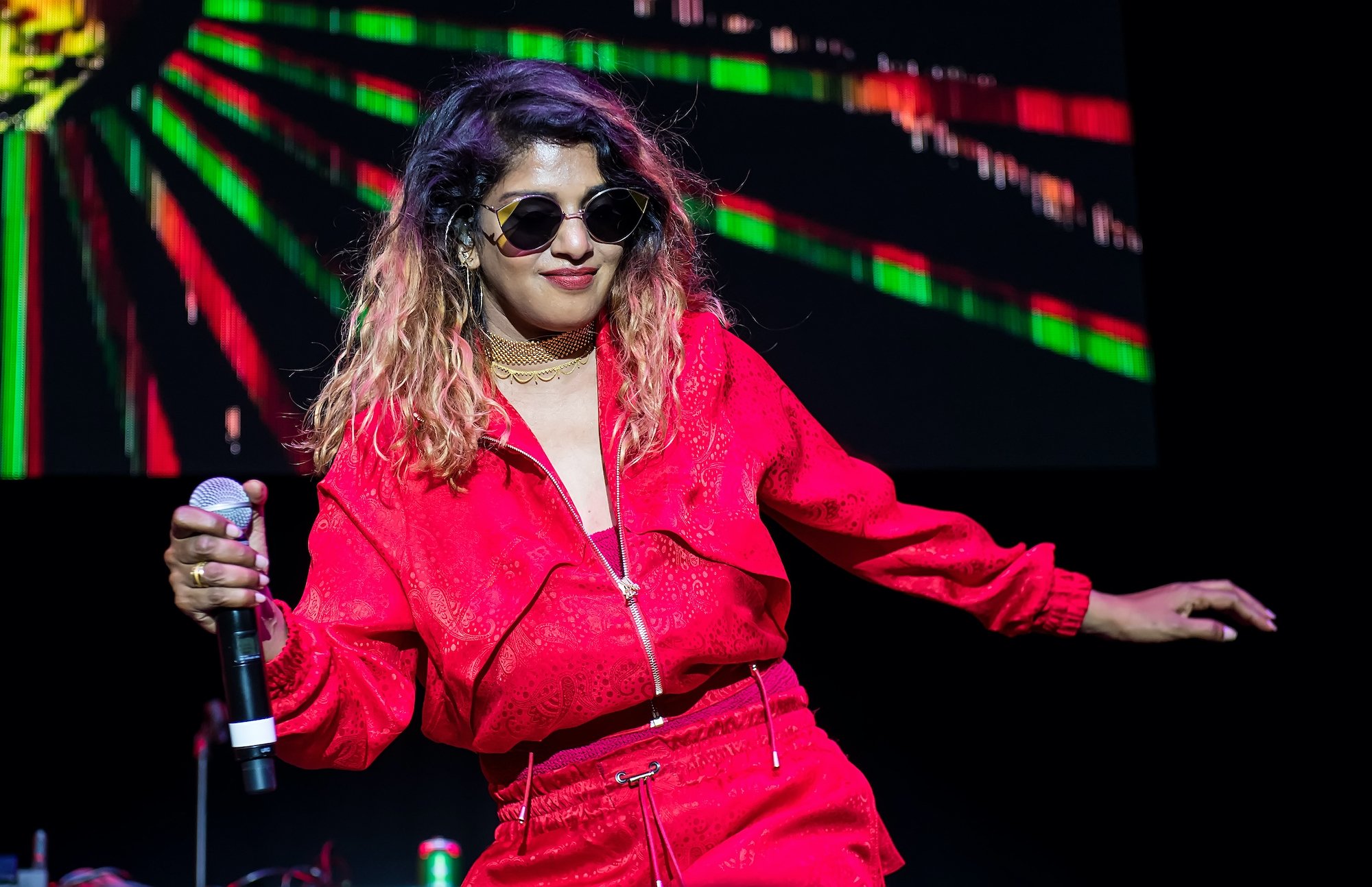 M.I.A smiling, holding a microphone on stage