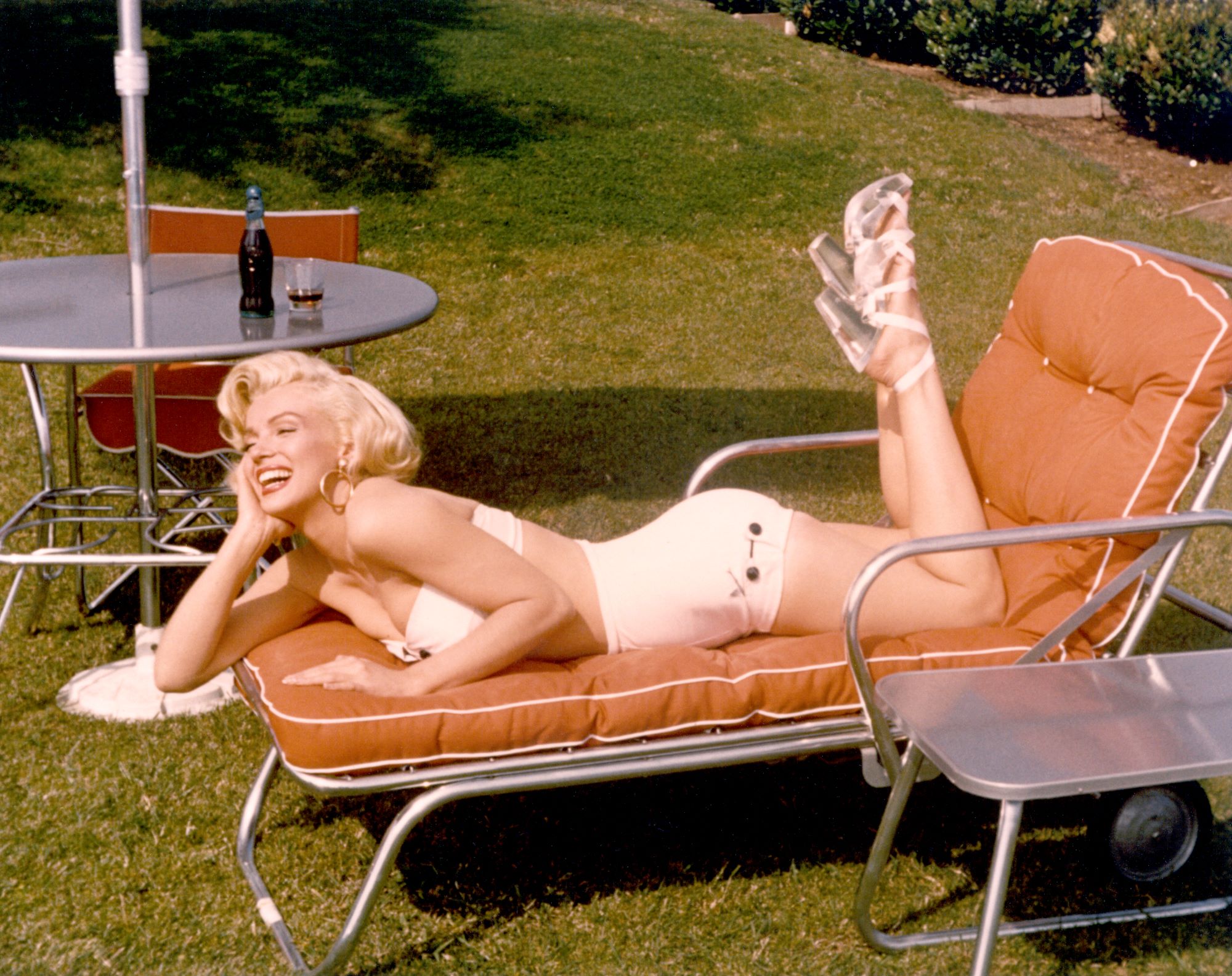 Marilyn Monroe in a swimsuit posing on a lawn chair