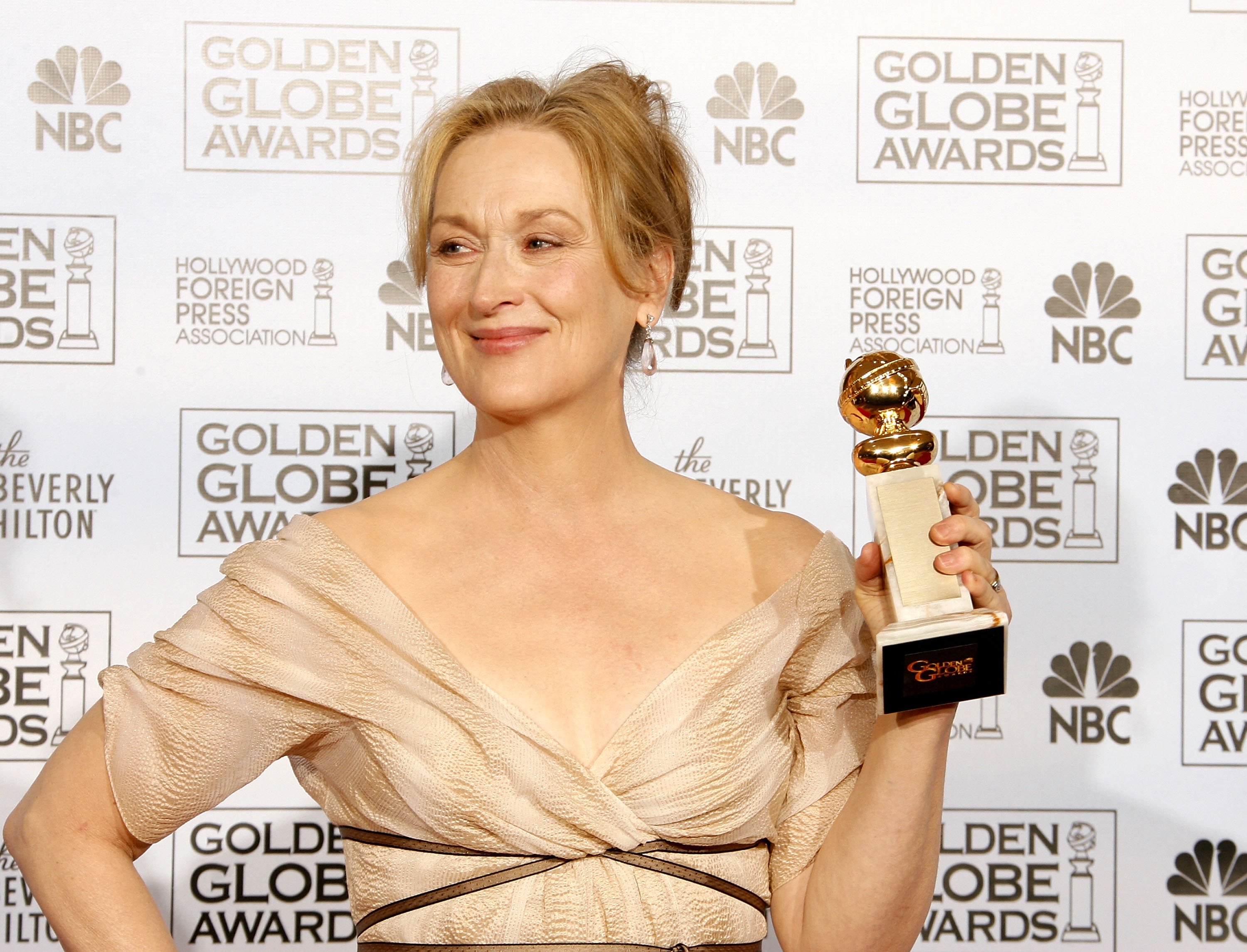 Meryl Streep holding a golden trophy for her role in 'The Devil Wears Prada'