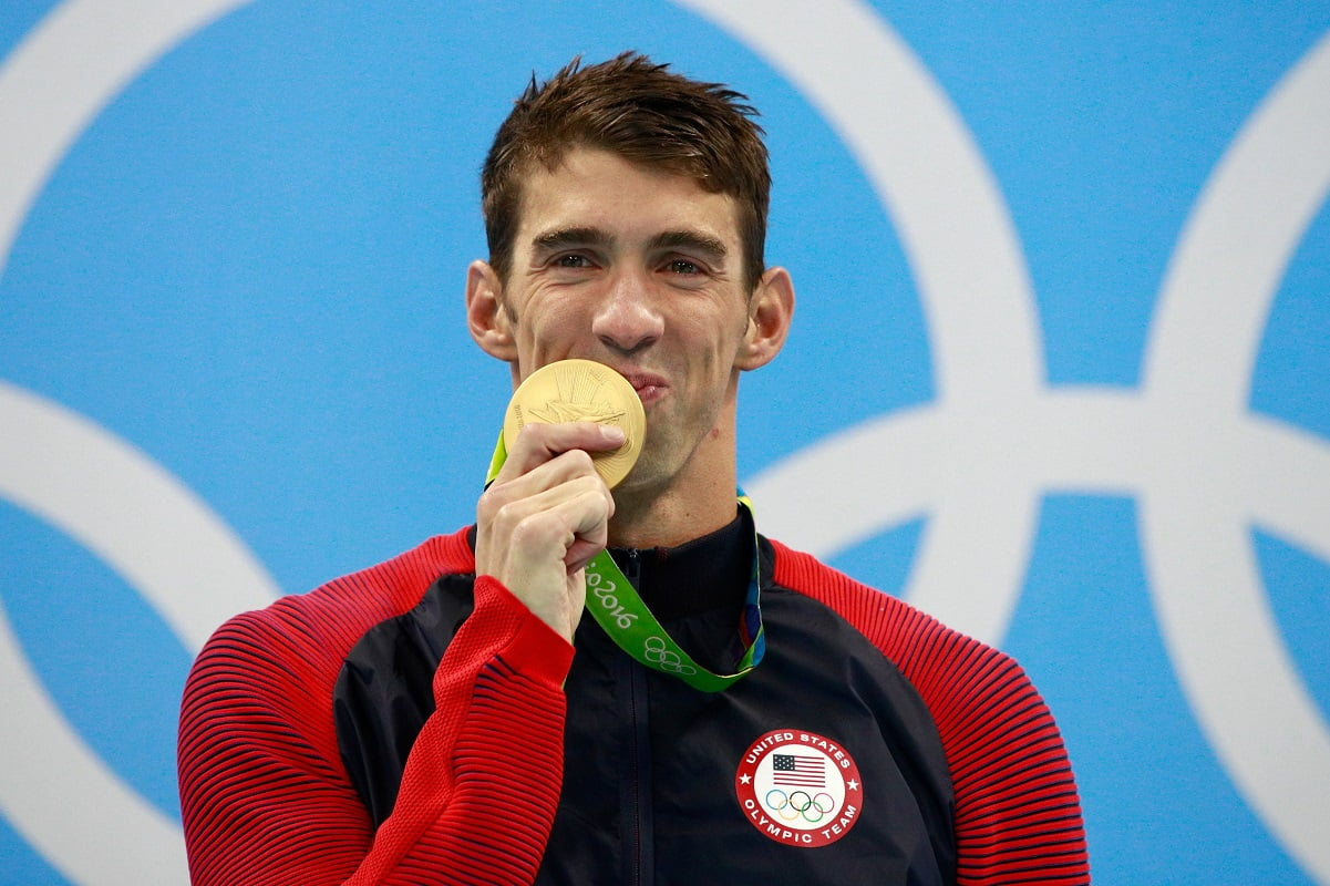 Michael Phelps celebrates, puts gold medal to his mouth after winning Men's 200m Individual Medley Final