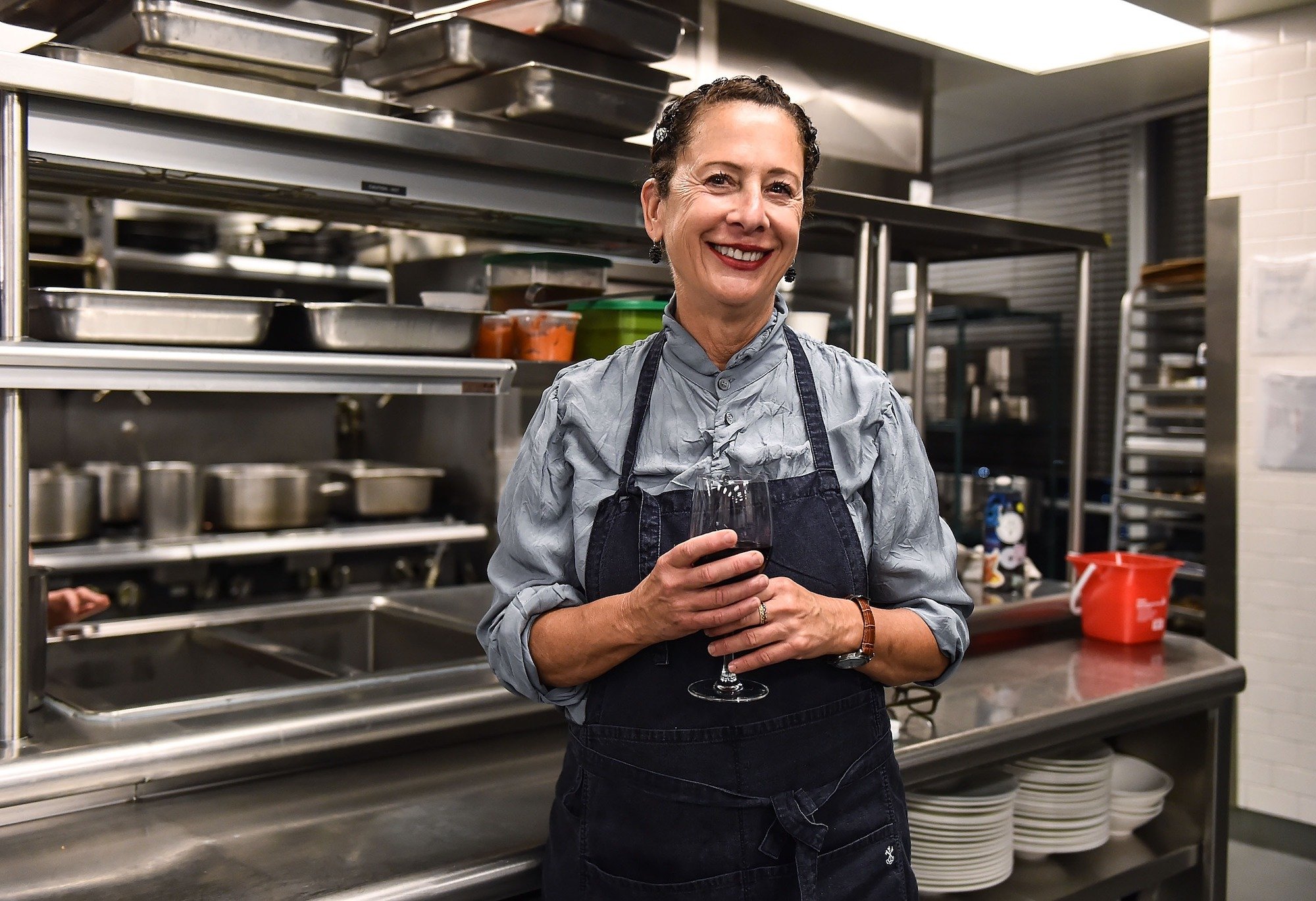 Nancy Silverton smiling, standing in a restaurant kitchen