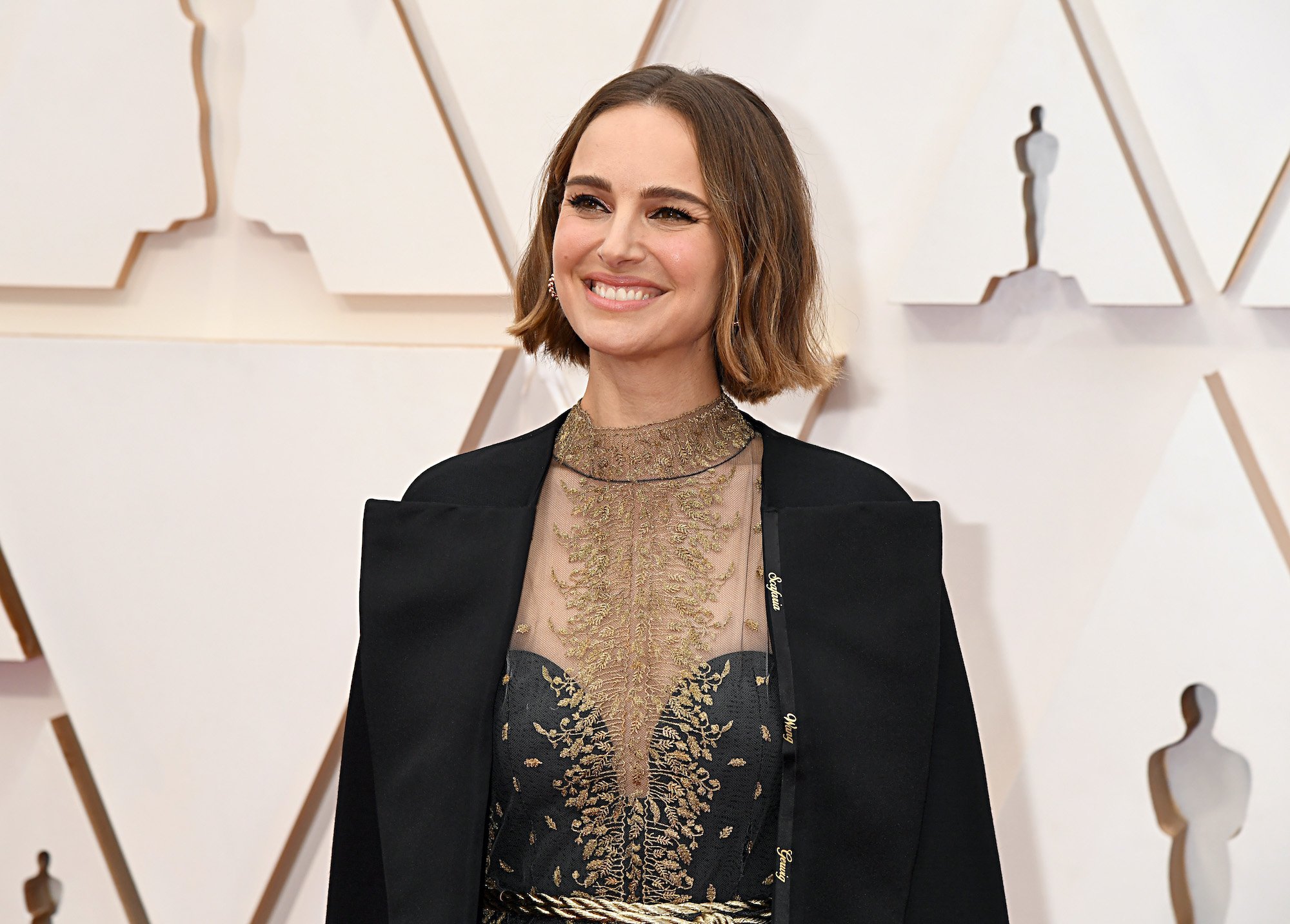 Natalie Portman smiling in front of a white background