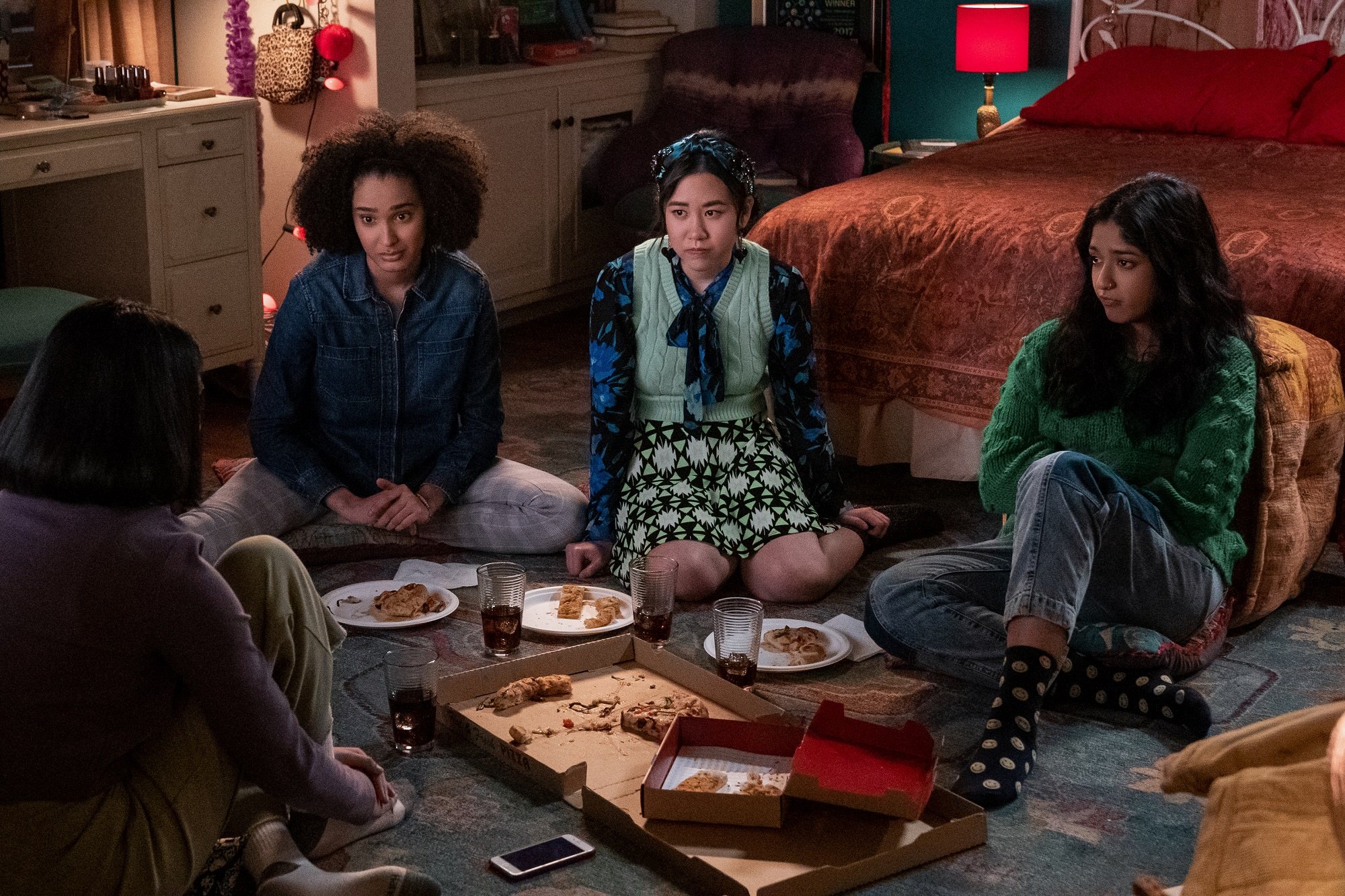 Aneesa, Fabiola, Eleanor, and Devi sit on the floor of Devi's bedroom in 'Never Have I Ever'