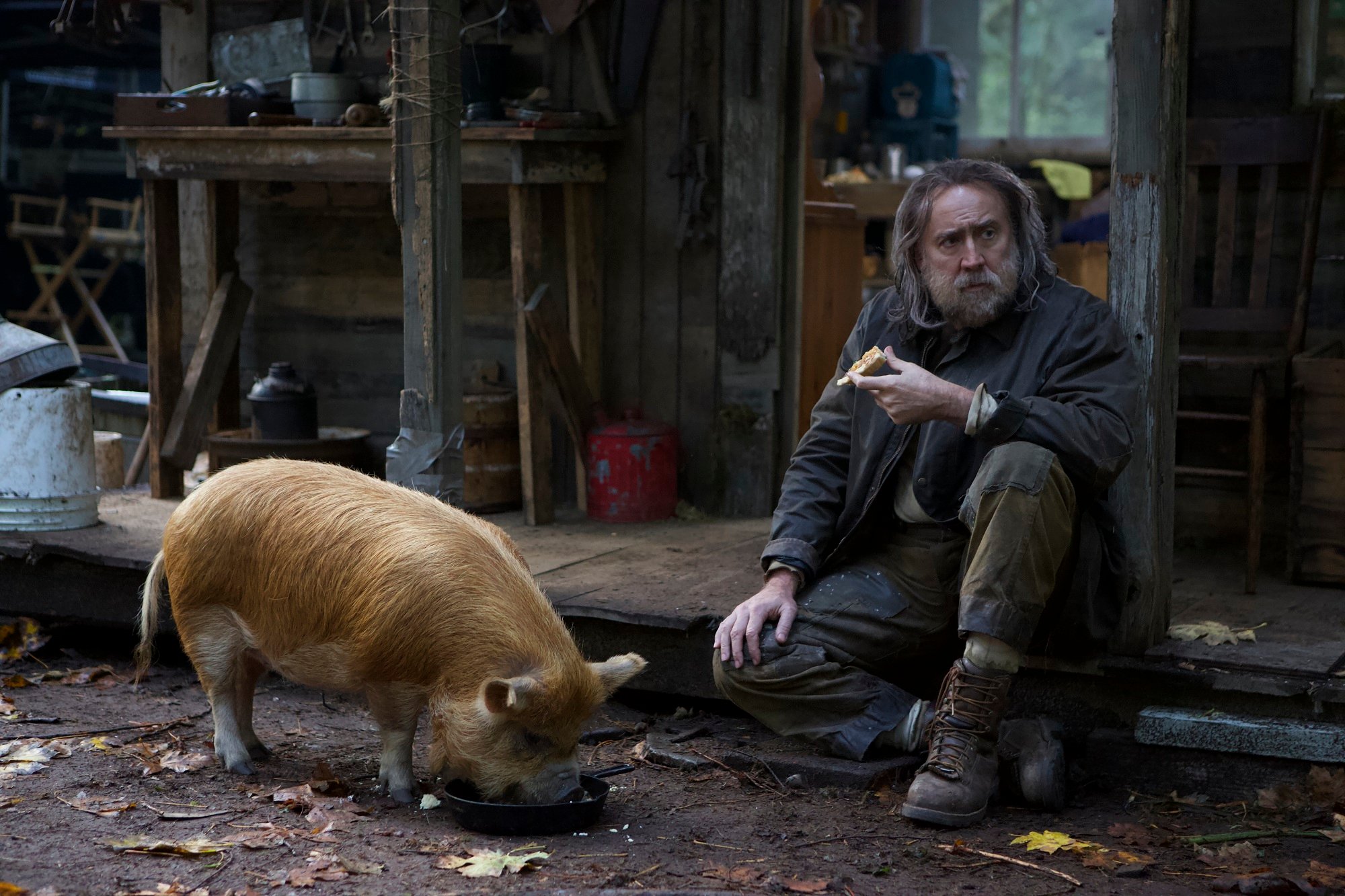 Nicolas Cage sits with his pig