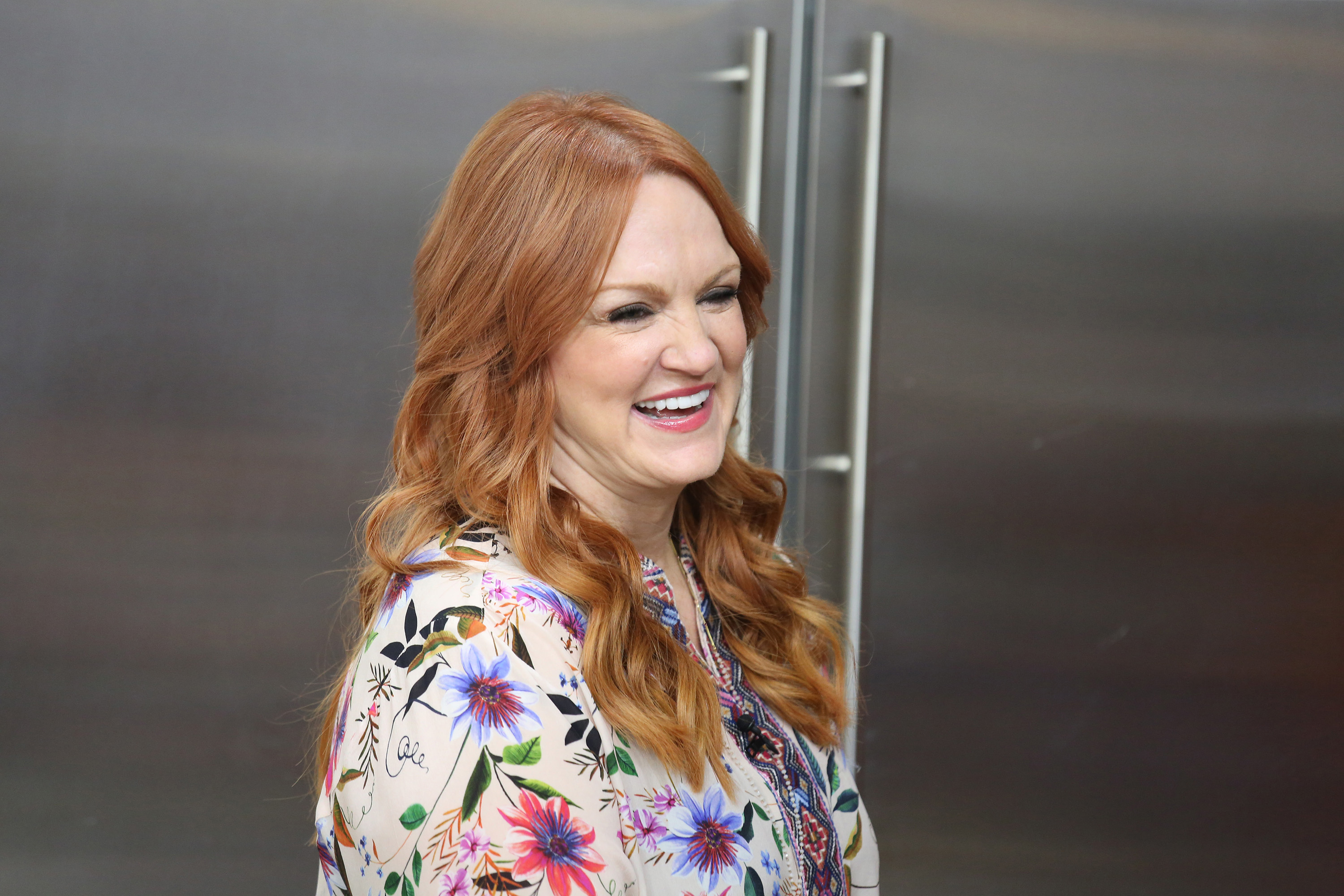 'The Pioneer Woman' host, Ree Drummond, wears a printed top and smiles at the camera.