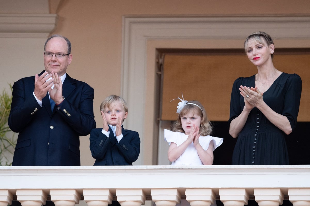 Prince Albert II of Monaco and Princess Charlene of Monaco clapping at event with their children Prince Jacques and Princess Gabriella