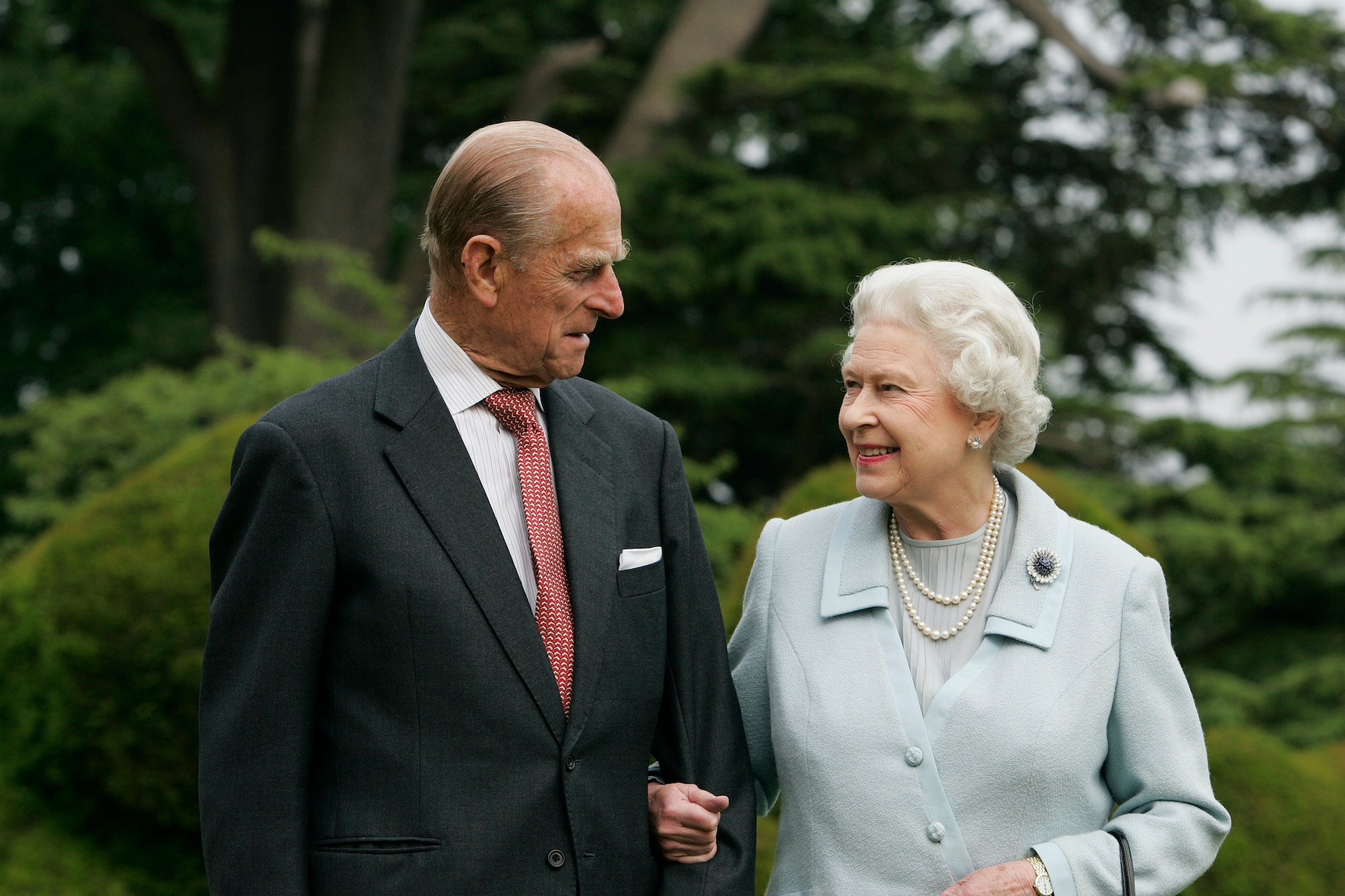 Prince Philip and Queen Elizabeth smiling at each other in front of blurred trees, 2007