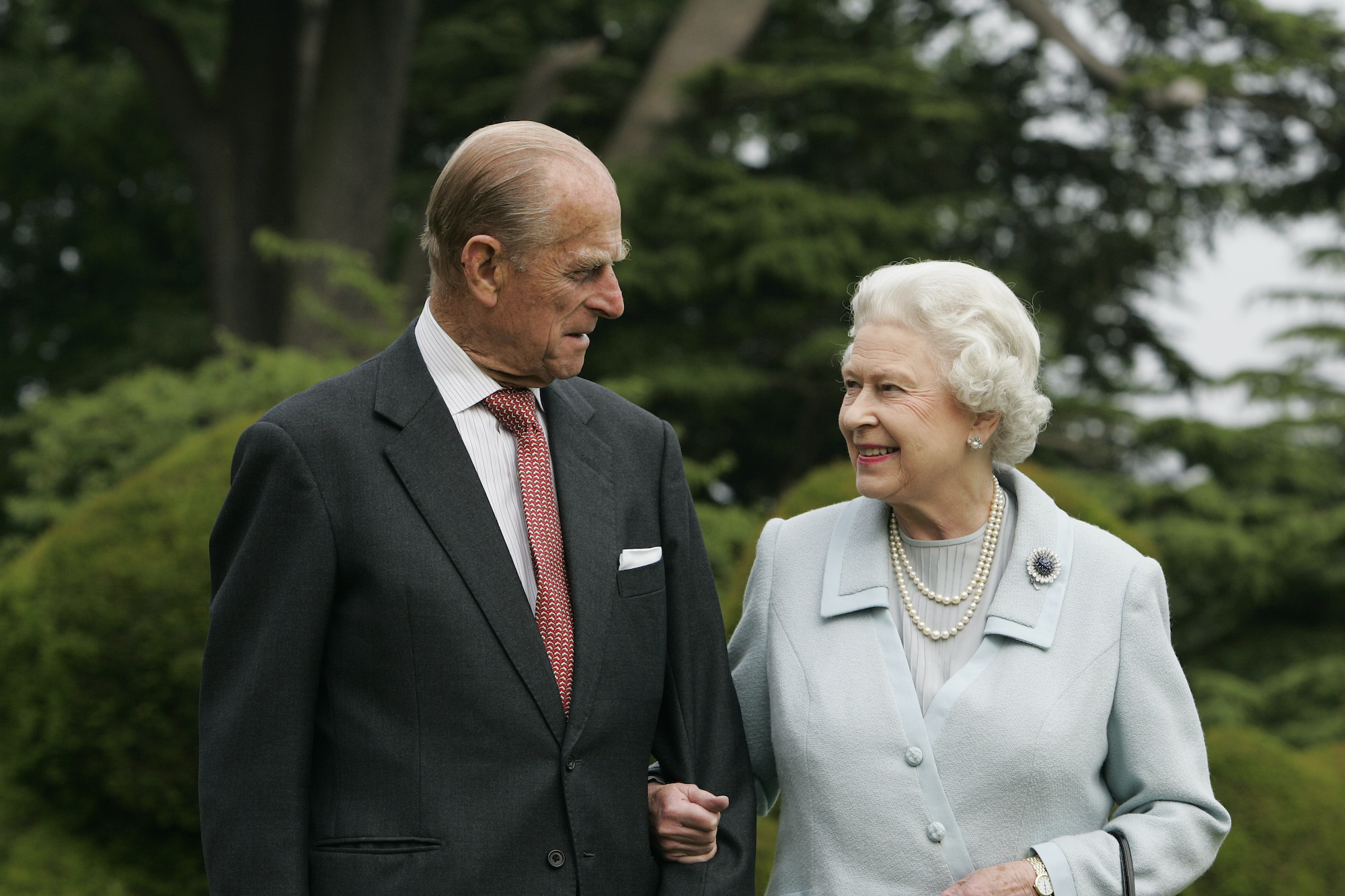 Prince Philip and Queen Elizabeth smiling at each other in front of blurred trees, 2007