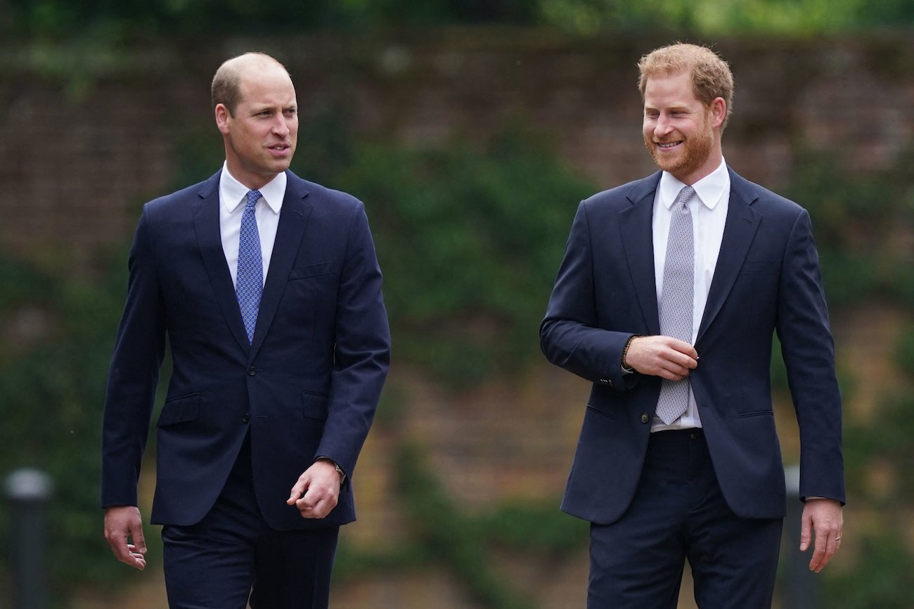 Prince William and Prince Harry walking next to each other wearing suits