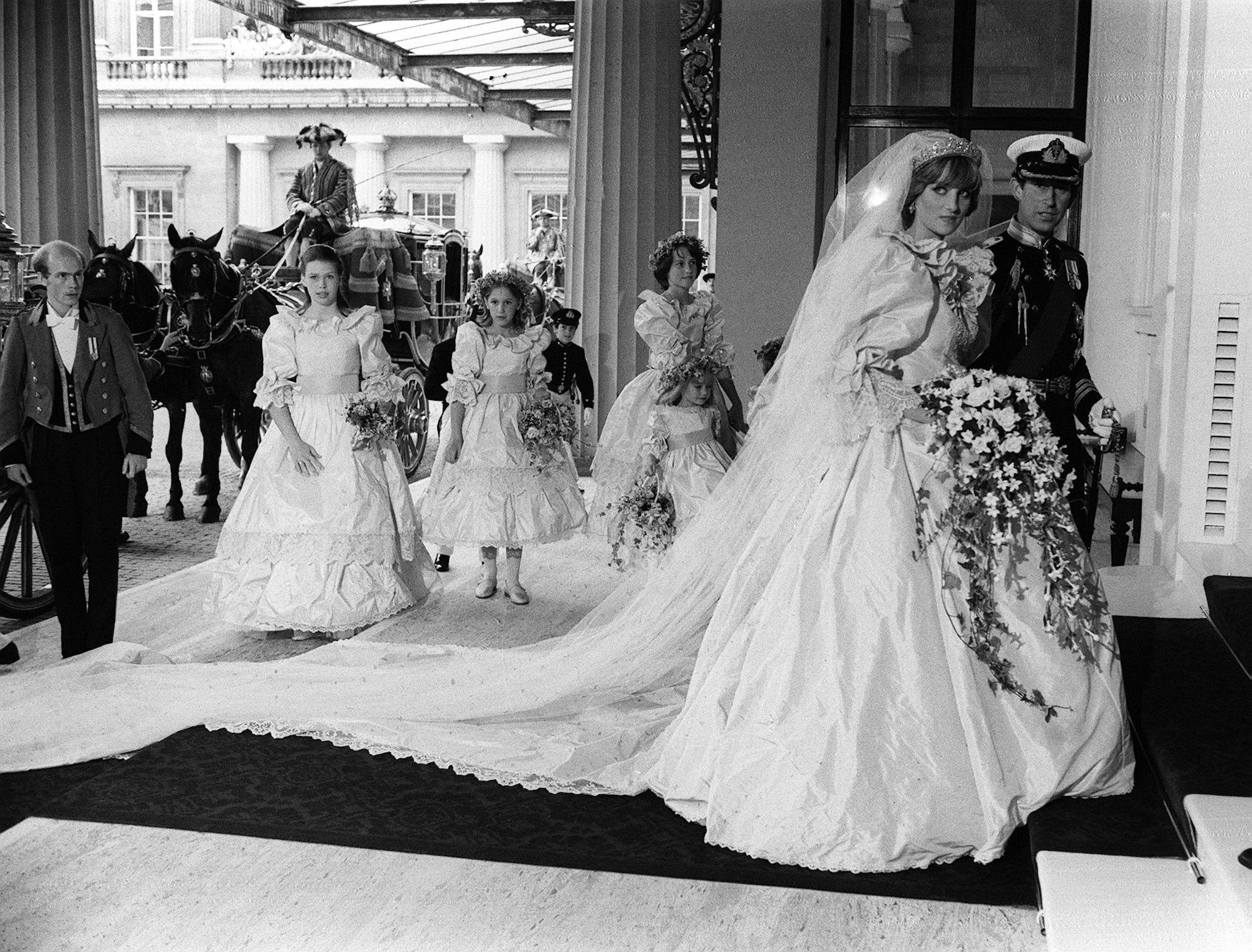 Princess Diana in one of the most iconic royal family looks, her 1981 wedding dress, walking with Prince Charles, in black and white. It's one of the royal family's best looks.