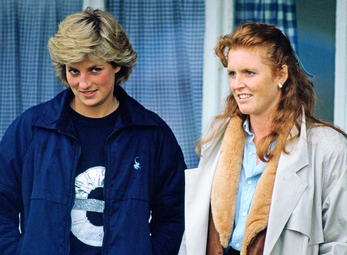 Princess Diana and Sarah Ferguson stand next to each as they watch a polo match
