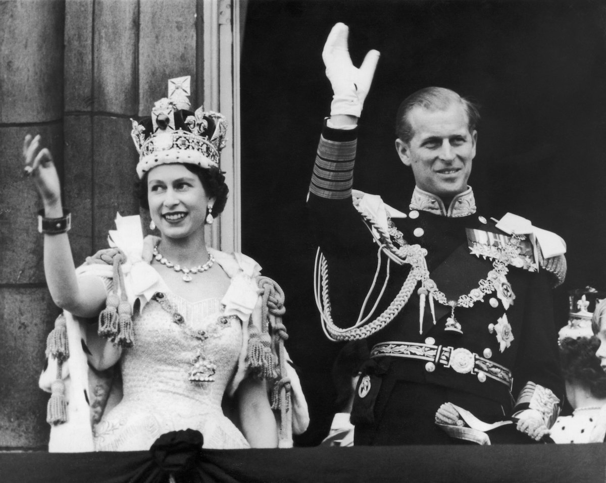 Queen Elizabeth II and the Duke of Edinburgh wave at the crowds from the balcony at Buckingham Palace after Elizabeth's coronation, 2nd June 1953.