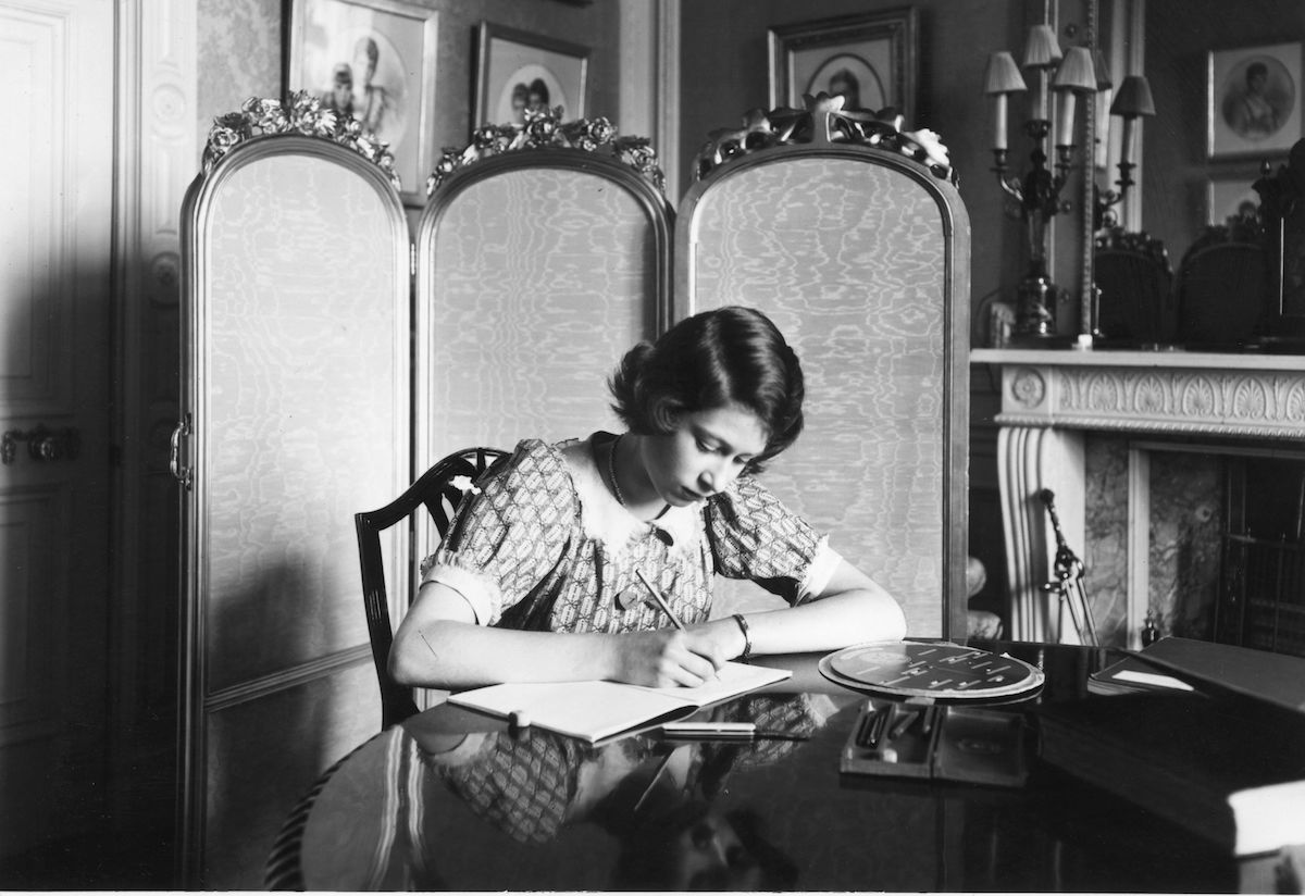 Princess Elizabeth working on her studies at a desk in Windsor Castle.