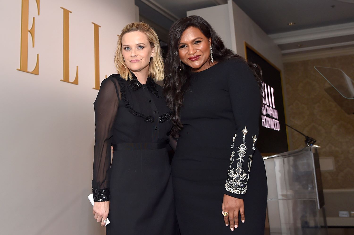Reese Witherspoon and Mindy Kaling posing together both in black dresses