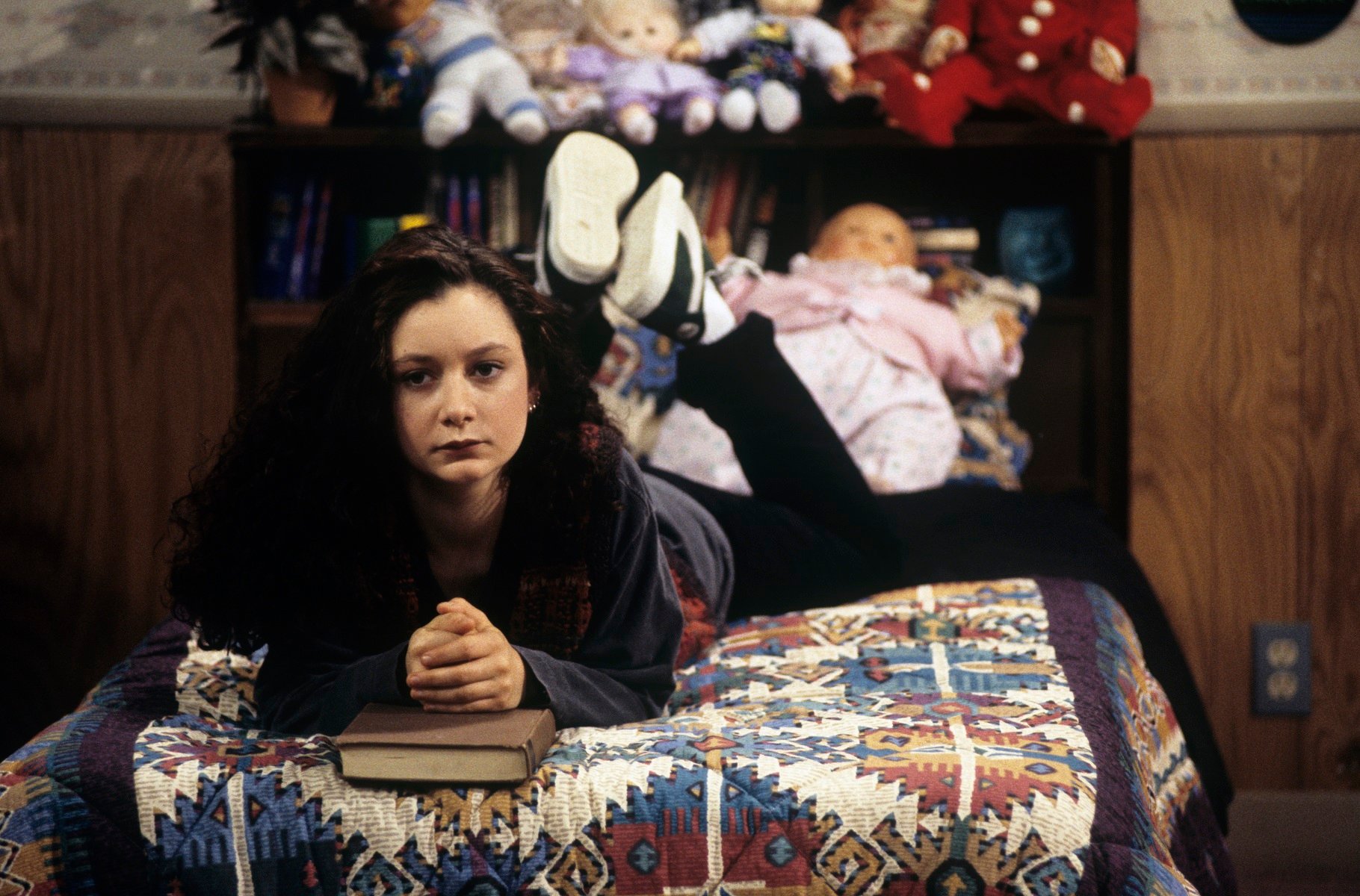 Sara Gilbert as Darlene Conner sits on her bed in the famous Conner home during a 1993 episode of 'Roseanne'