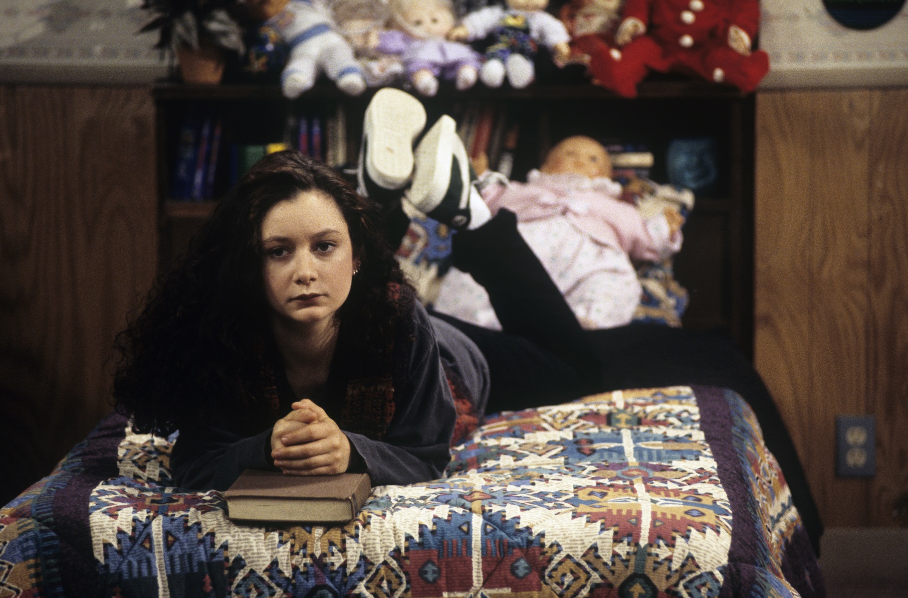 Sara Gilbert as Darlene Conner sits on her bed in the famous Conner home during a 1993 episode of 'Roseanne'