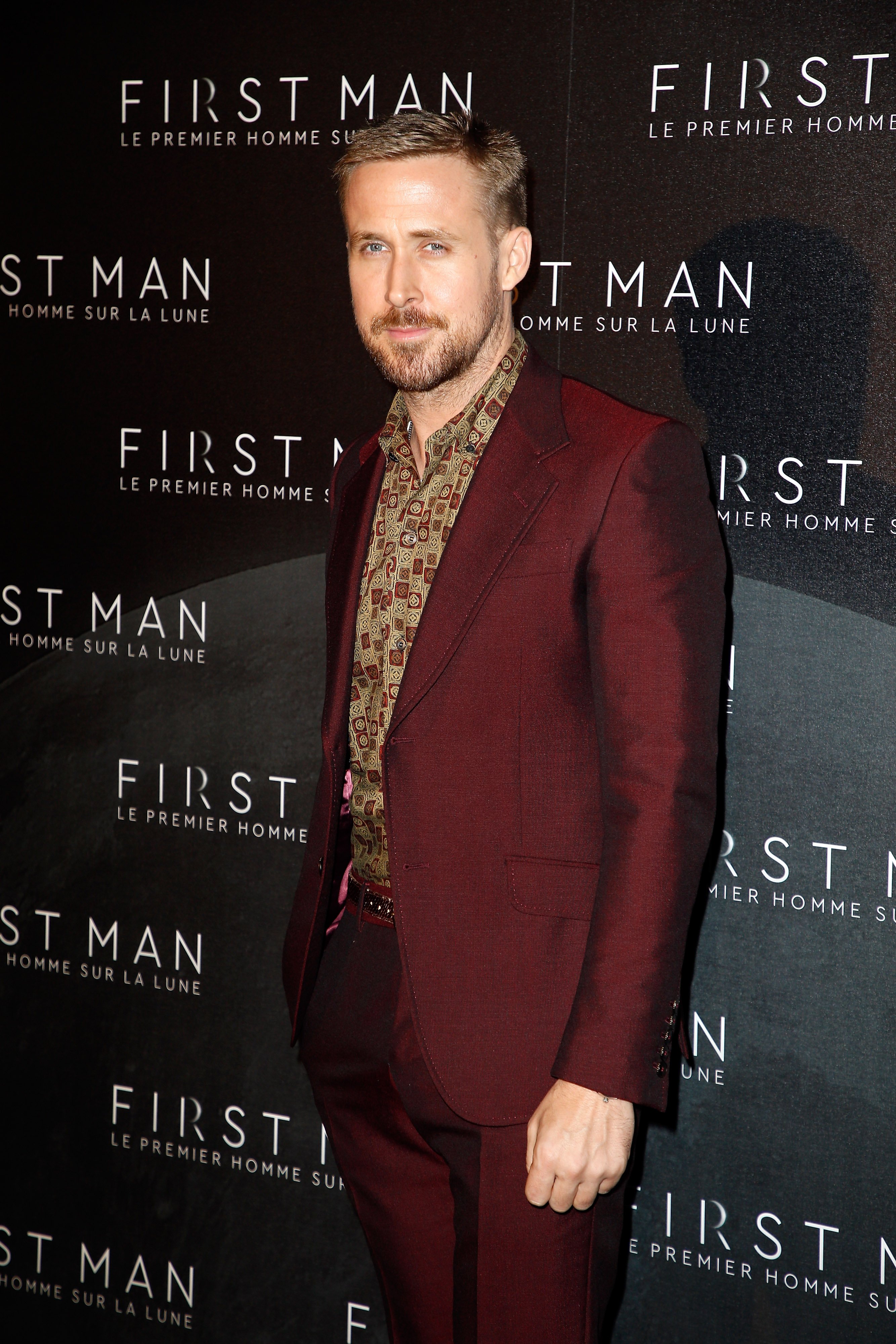 Actor Ryan Gosling poses for photo in a maroon suit at at the 'First Man Paris' premiere