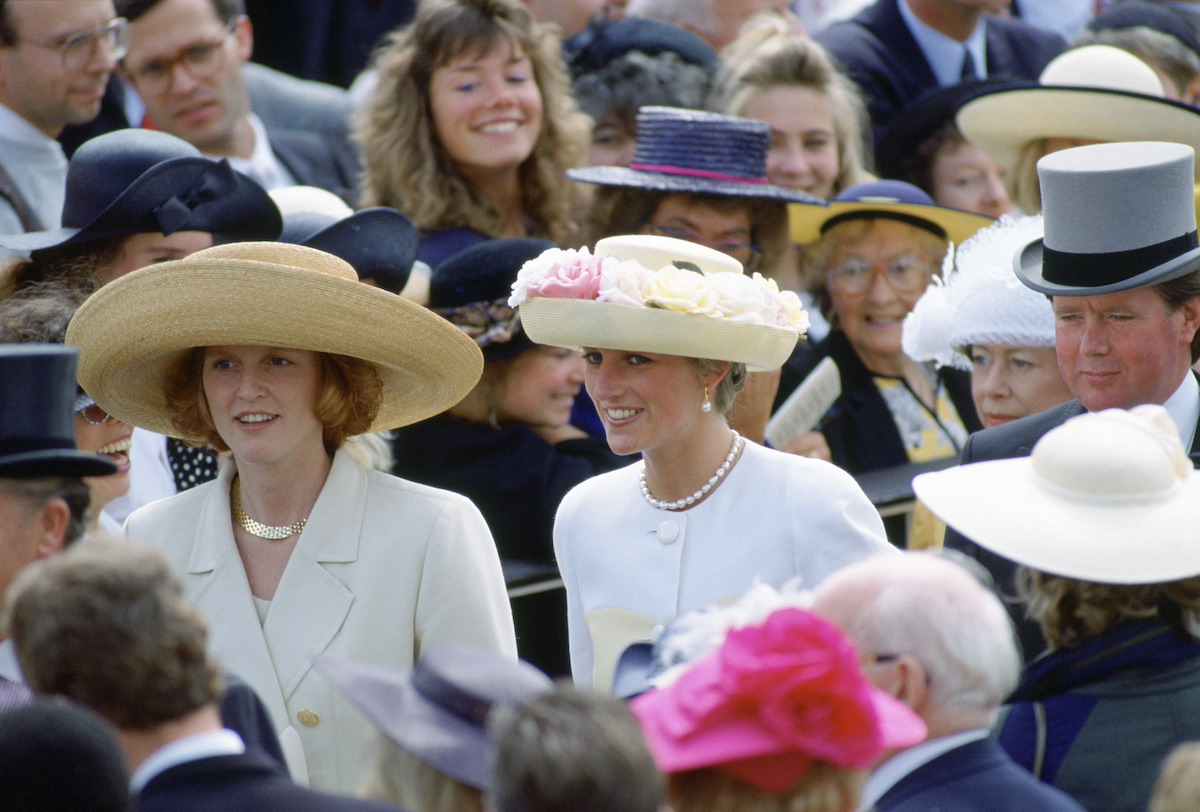 Sarah Ferguson and Princess Diana smile as they walk through the crowd at the Ascot Races