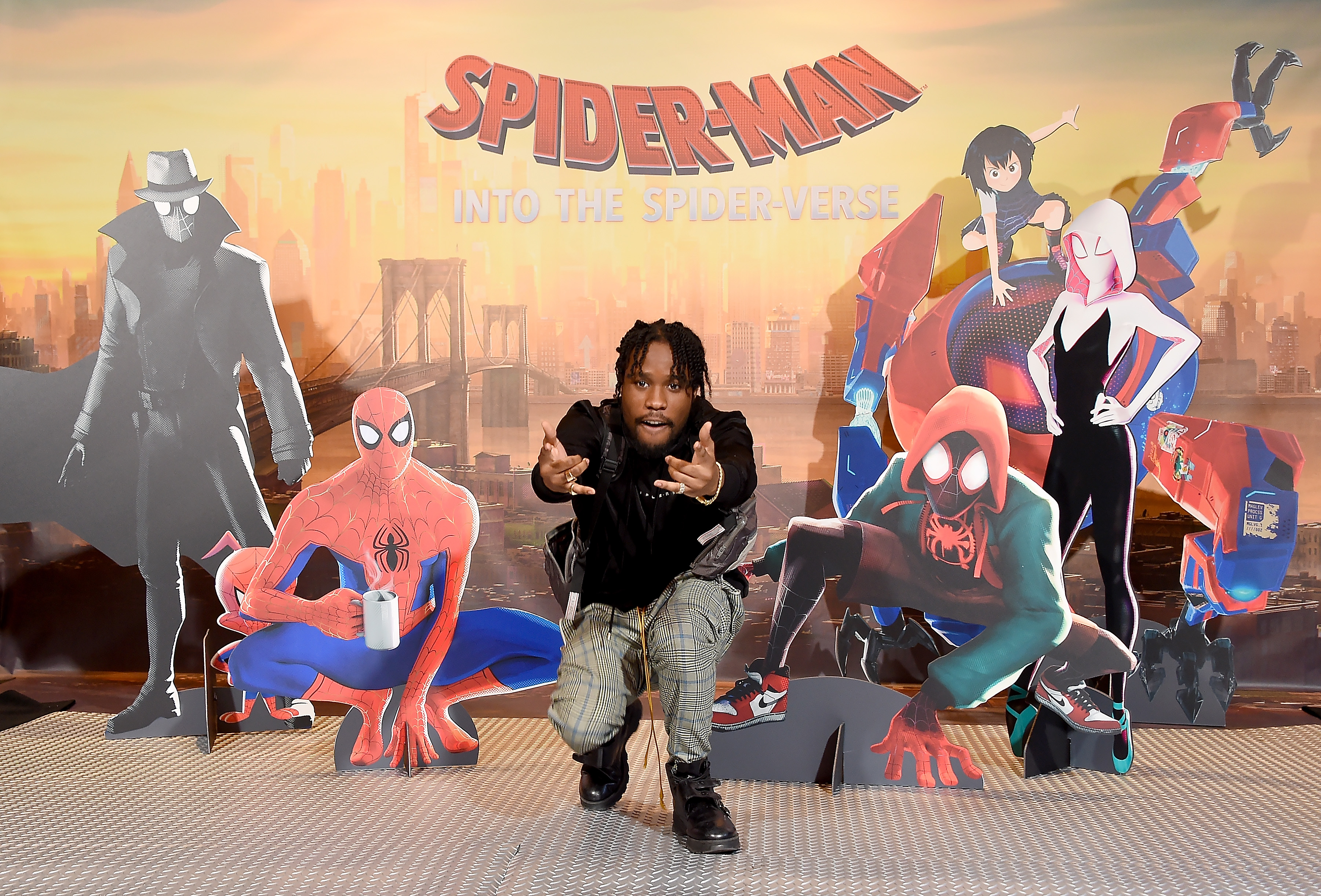 Shameik Moore poses for a photo with cardboard cutouts of the characters from 'Spider-Man Into the Spider-Verse'