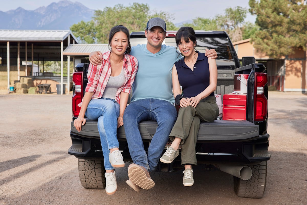 Christine Ko, Wes Brown, and Lauren Tom sitting on the back of a truck in 'Sweet Pecan Summer'