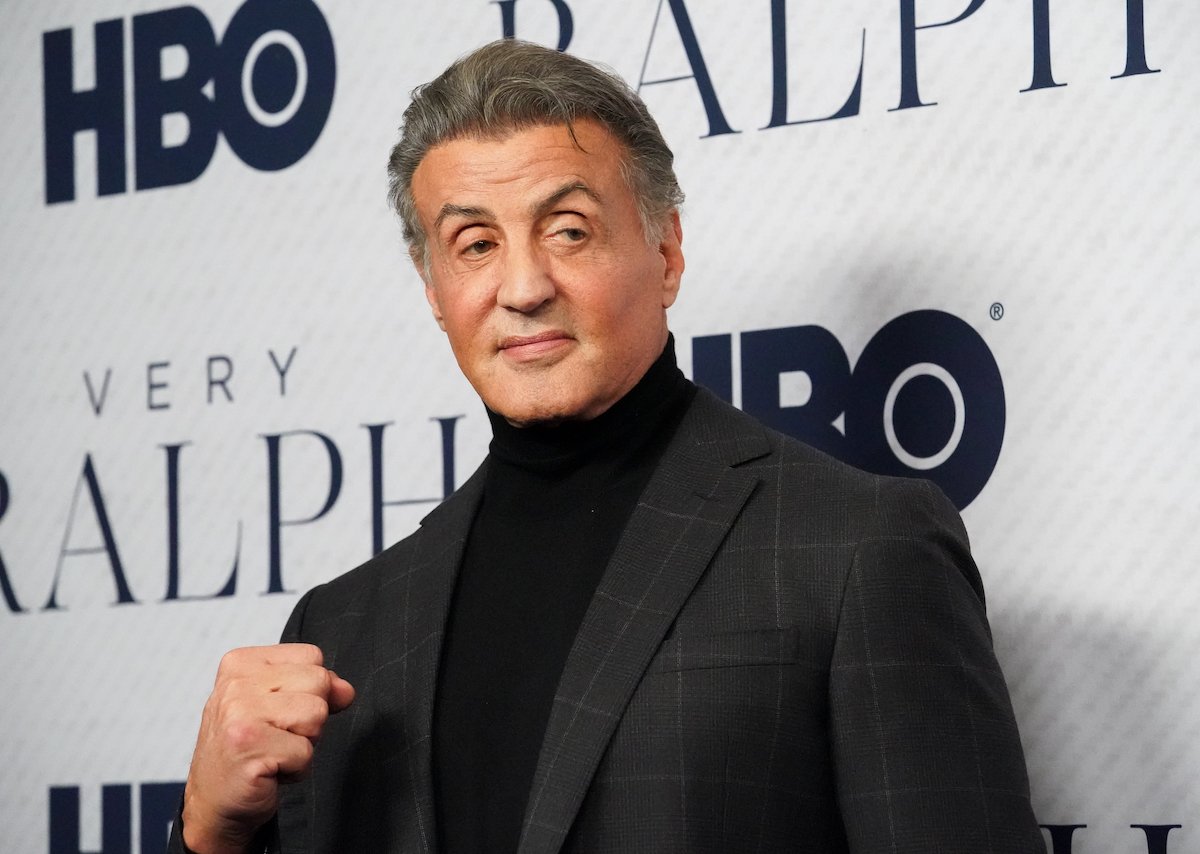 Sylvester Stallone wears a suit and poses on the red carpet