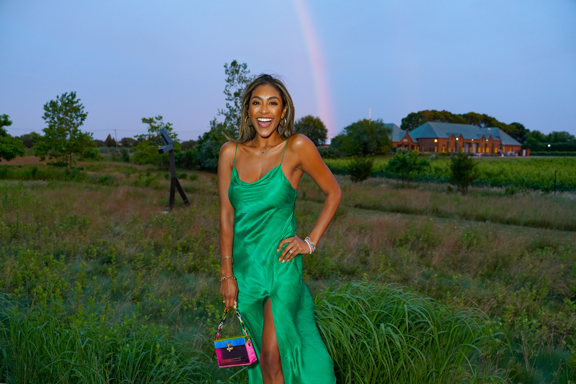 Tayshia Adams smiling in a green dress