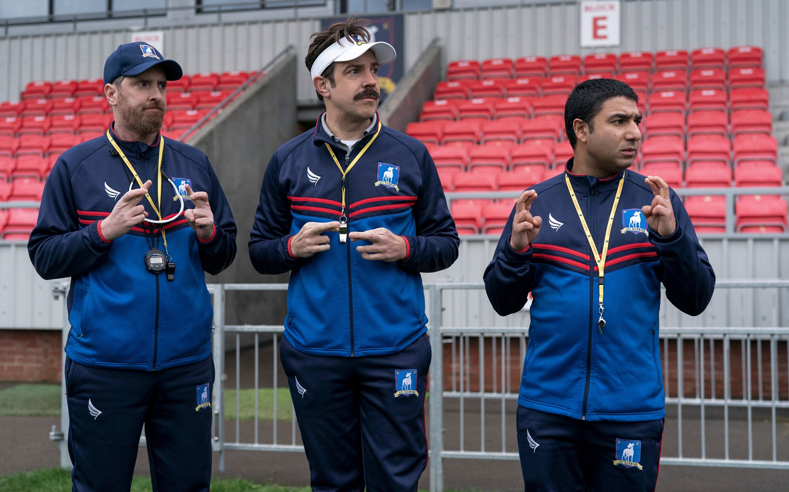'Ted Lasso' Season 2 Episode 1 still with Brendan Hunt, Jason Sudeikis, and Nick Mohammed crossing their fingers