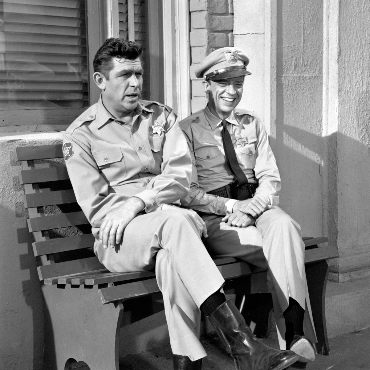 Andy Griffith and Don Knotts sit on a bench outside the Mayberry courthouse in 'The Andy Griffith Show'