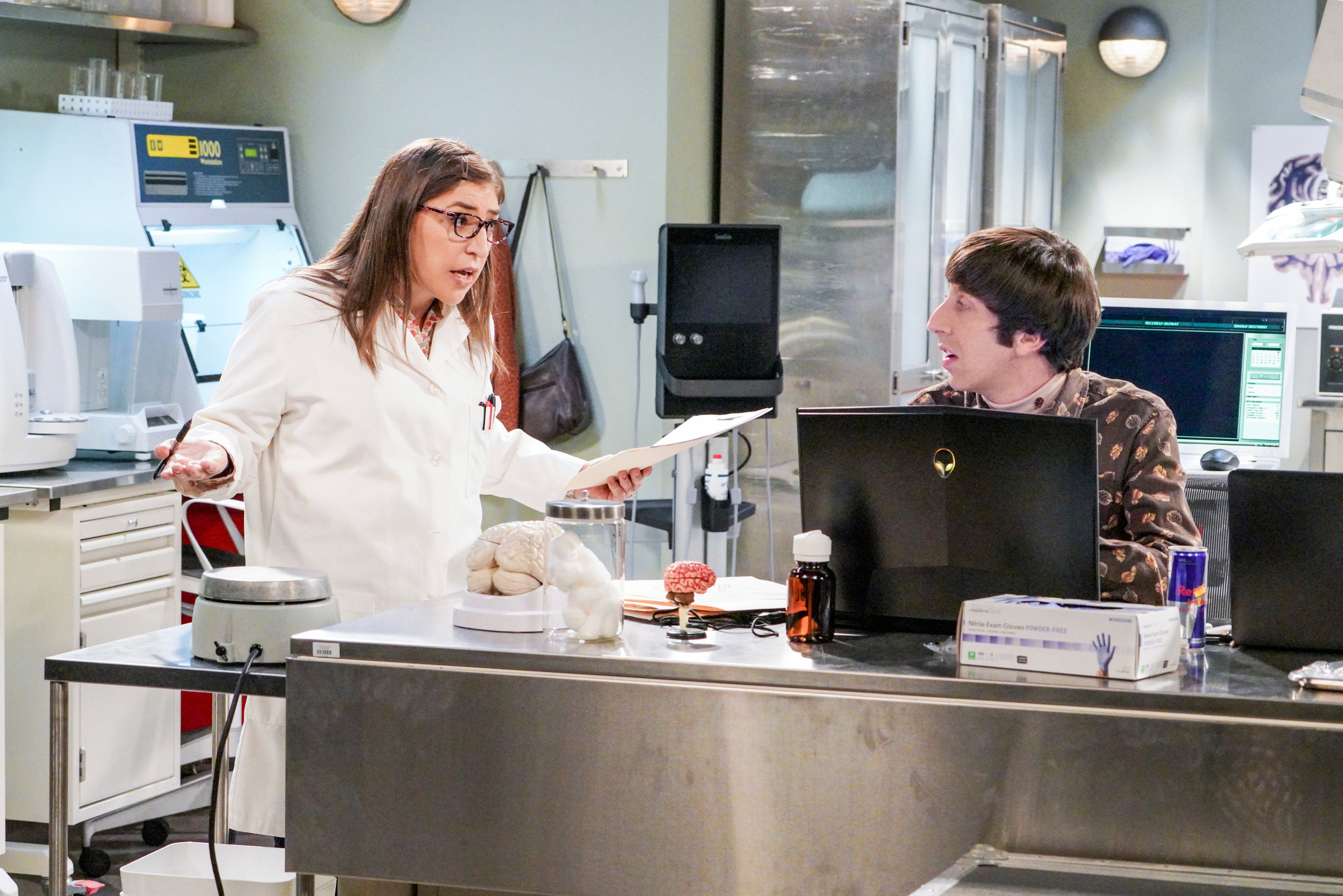 Amy Farrah Fowler looks at Howard Wolowitz expectantly in a shared lab space during "The Neonatal Nomenclature"