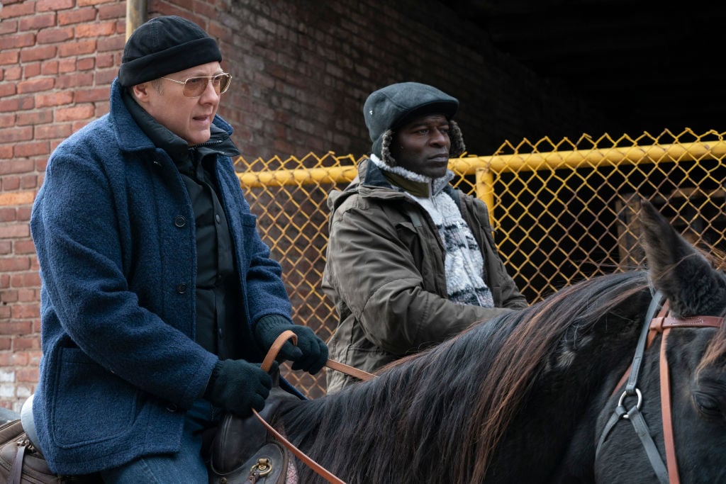 Raymond Reddington and Dembe Zuma ride horses net to each other in the brisk air.