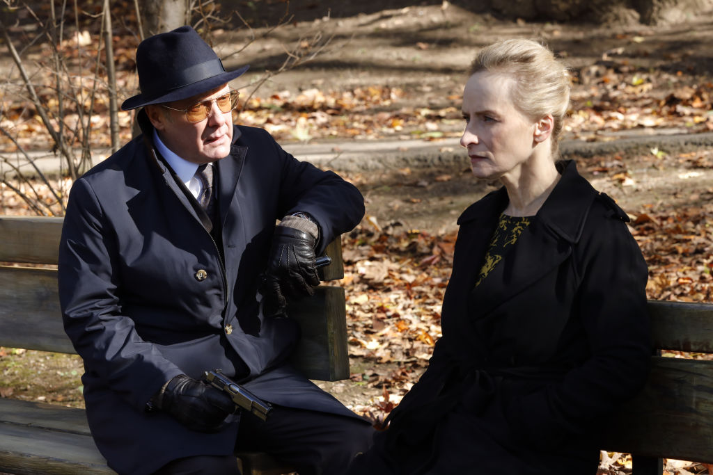 James Spader as Raymond 'Red' Reddington sits next to Laila Robins as Katarina Rostova on a park bench.